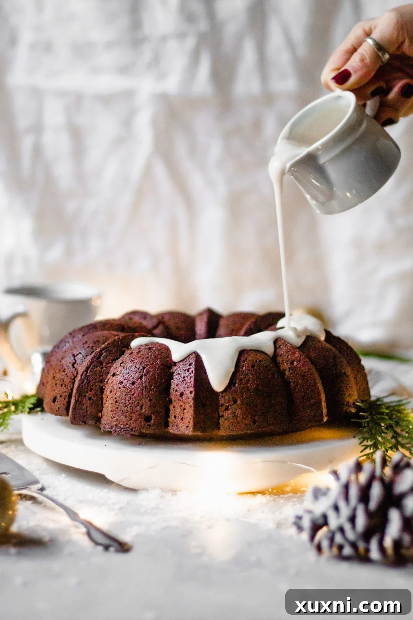 hand drizzling dairy free glaze onto gingerbread bundt cake