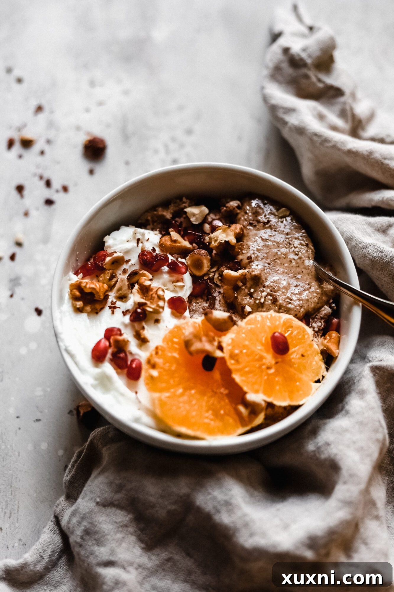 Close-up of a Paleo grain-free oatmeal bowl topped with fresh berries and nuts.