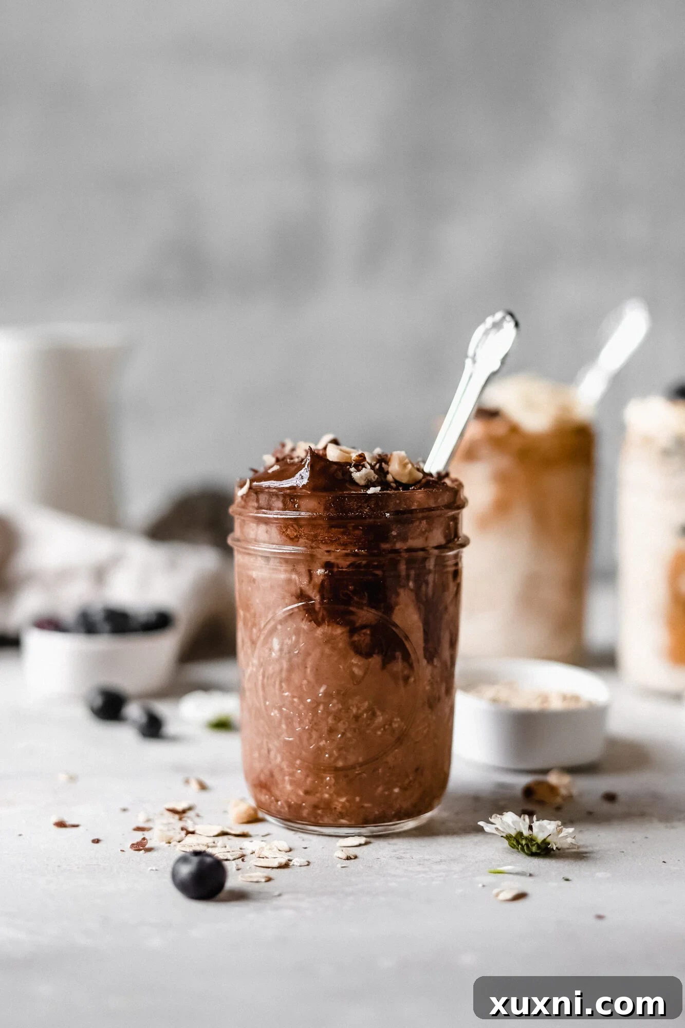 Jar of rich chocolate hazelnut vegan overnight oats with whole hazelnuts