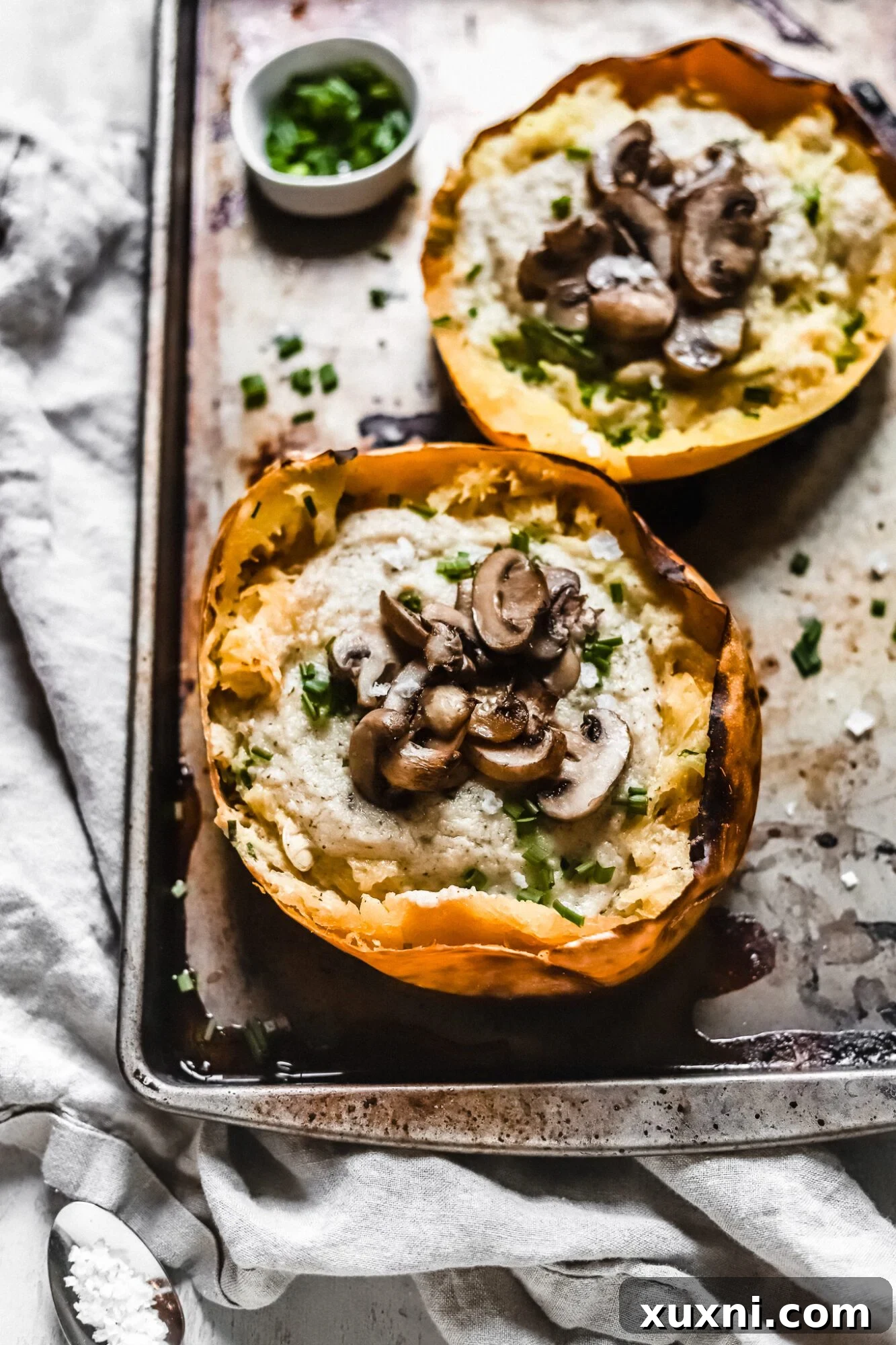 Close up of a spaghetti squash boat brimming with creamy vegan Alfredo sauce, ready to be enjoyed.