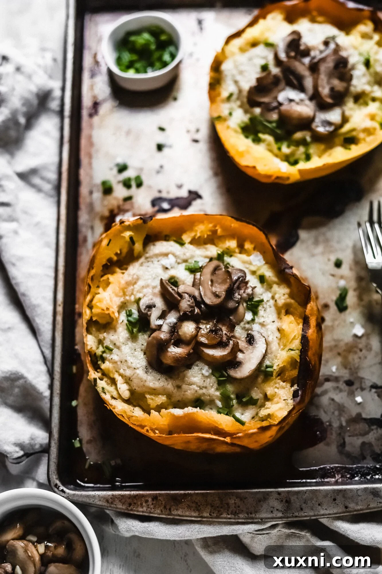 A close-up view of mushrooms glistening in a spaghetti squash boat, ready for the final baking step.