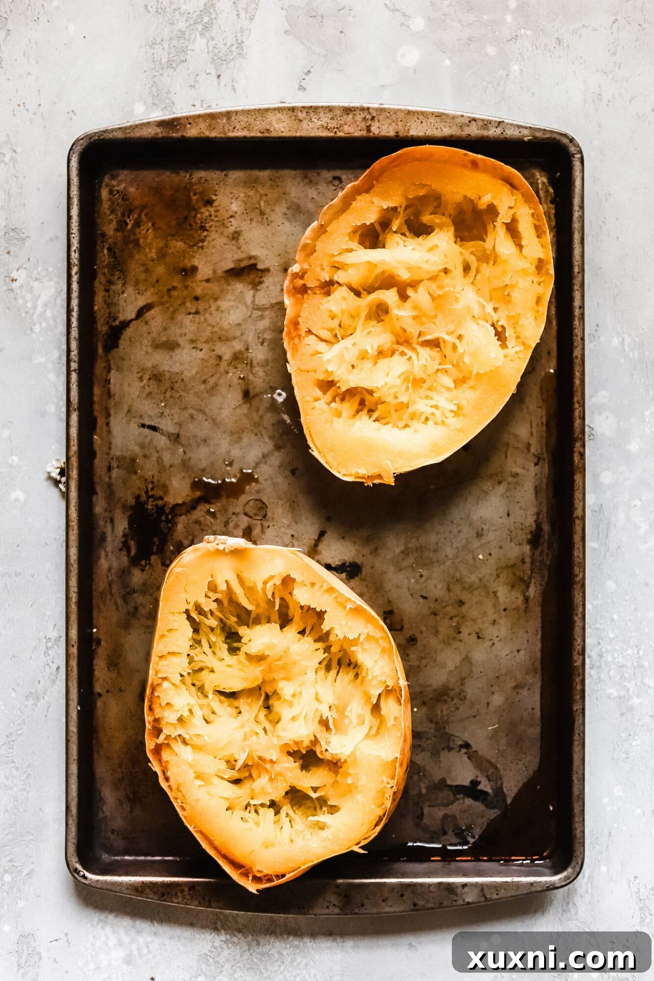 Halved and baked spaghetti squash, its golden strands visible, ready to be transformed into delicious boats.