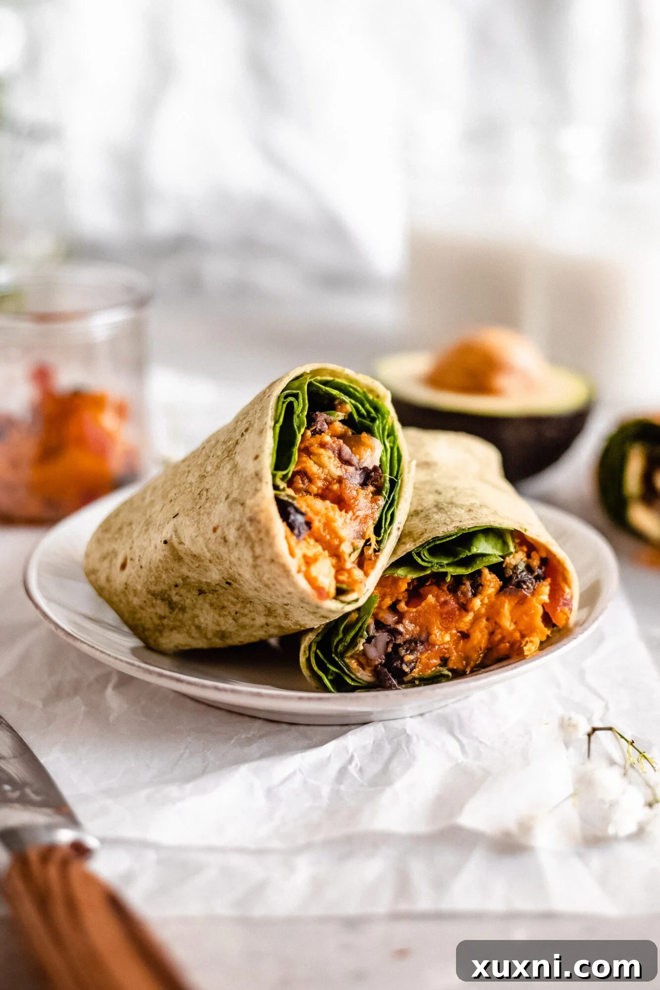 A hearty sweet potato and black bean burrito, showing the wholesome vegetable and legume filling