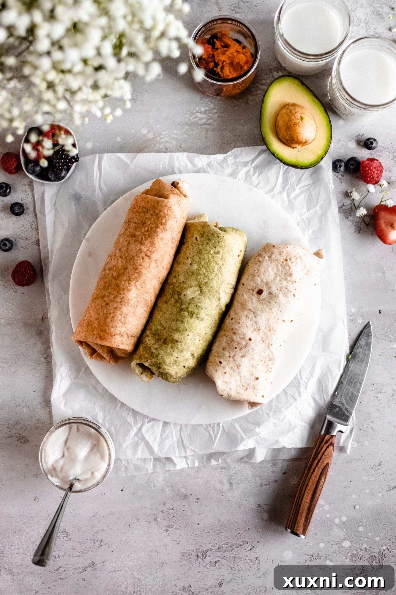 Three prepared vegan breakfast burritos on a plate, ready to be enjoyed