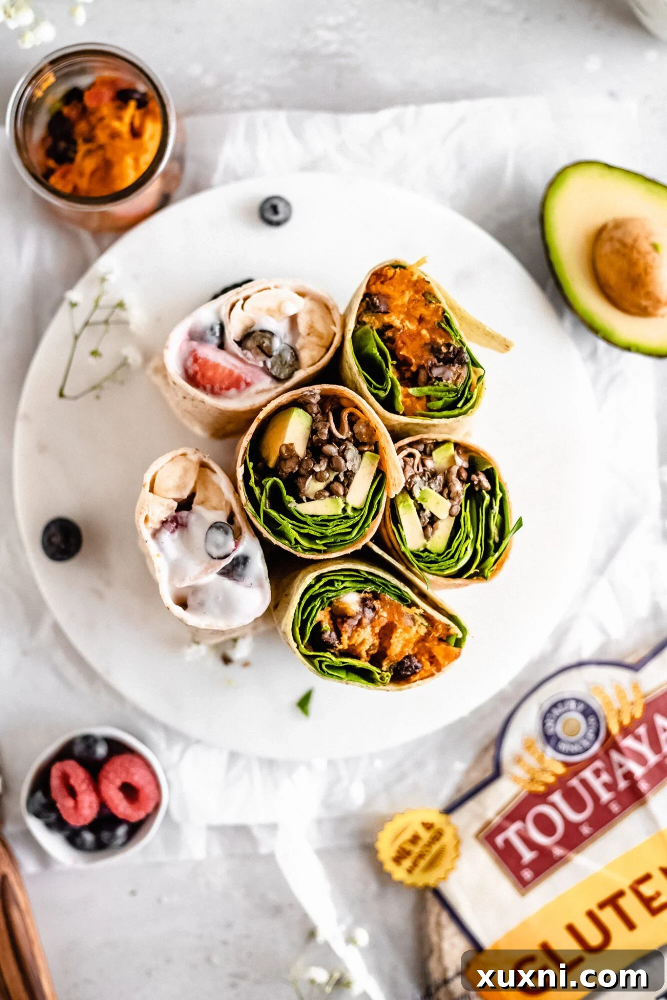 Two breakfast burritos sliced in half, revealing the vibrant fillings