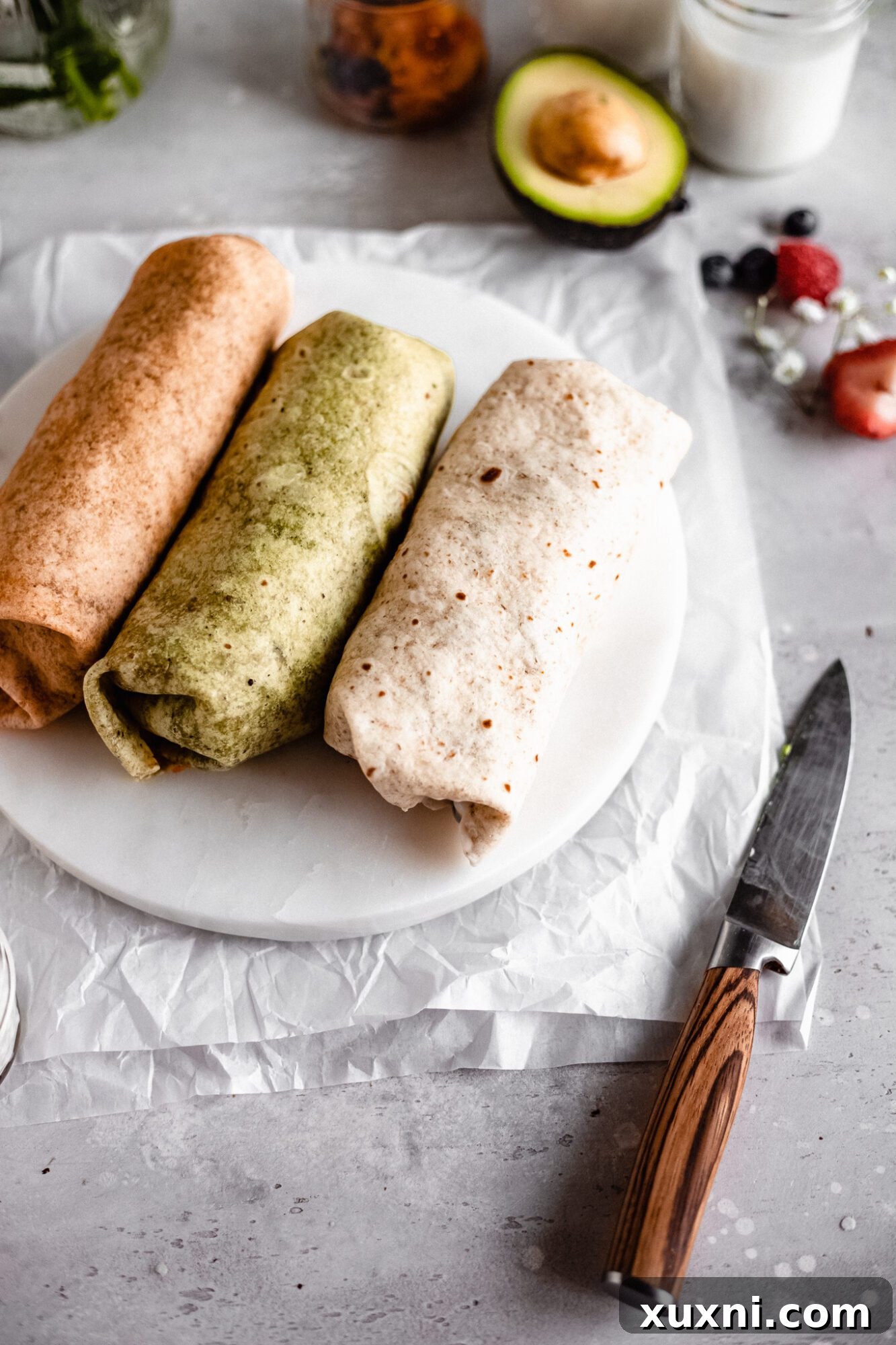 Several vegan breakfast burritos, neatly wrapped and ready to eat
