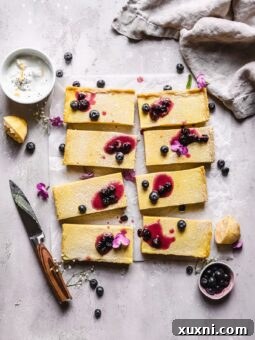 sliced Paleo vegan lemon bars with blueberry jam on top with a knife next to it