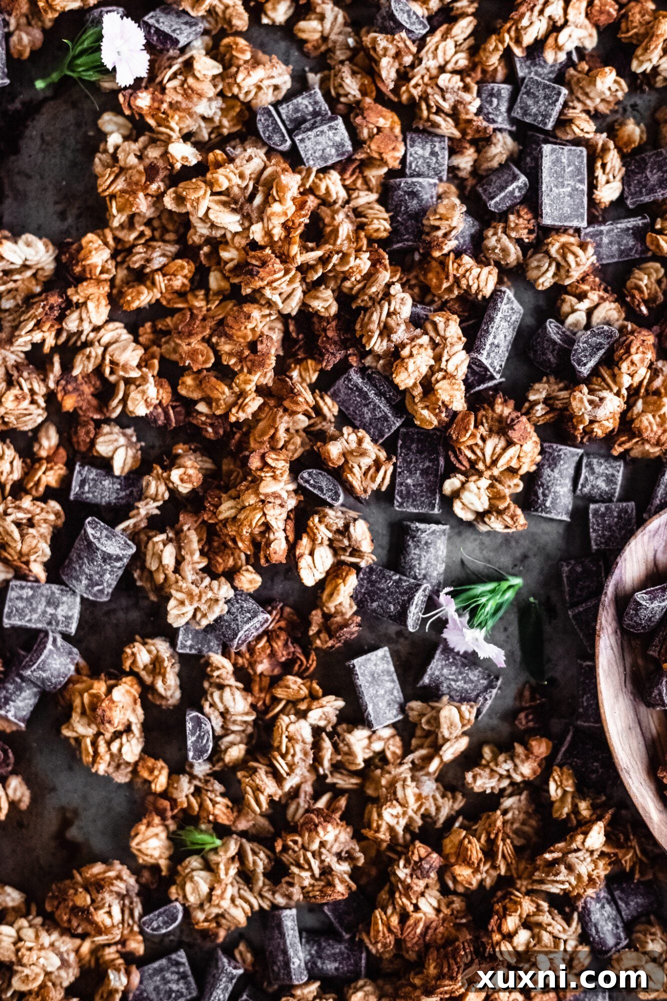 Freshly mixed granola spread evenly on a baking sheet, ready to be baked to crispy perfection.