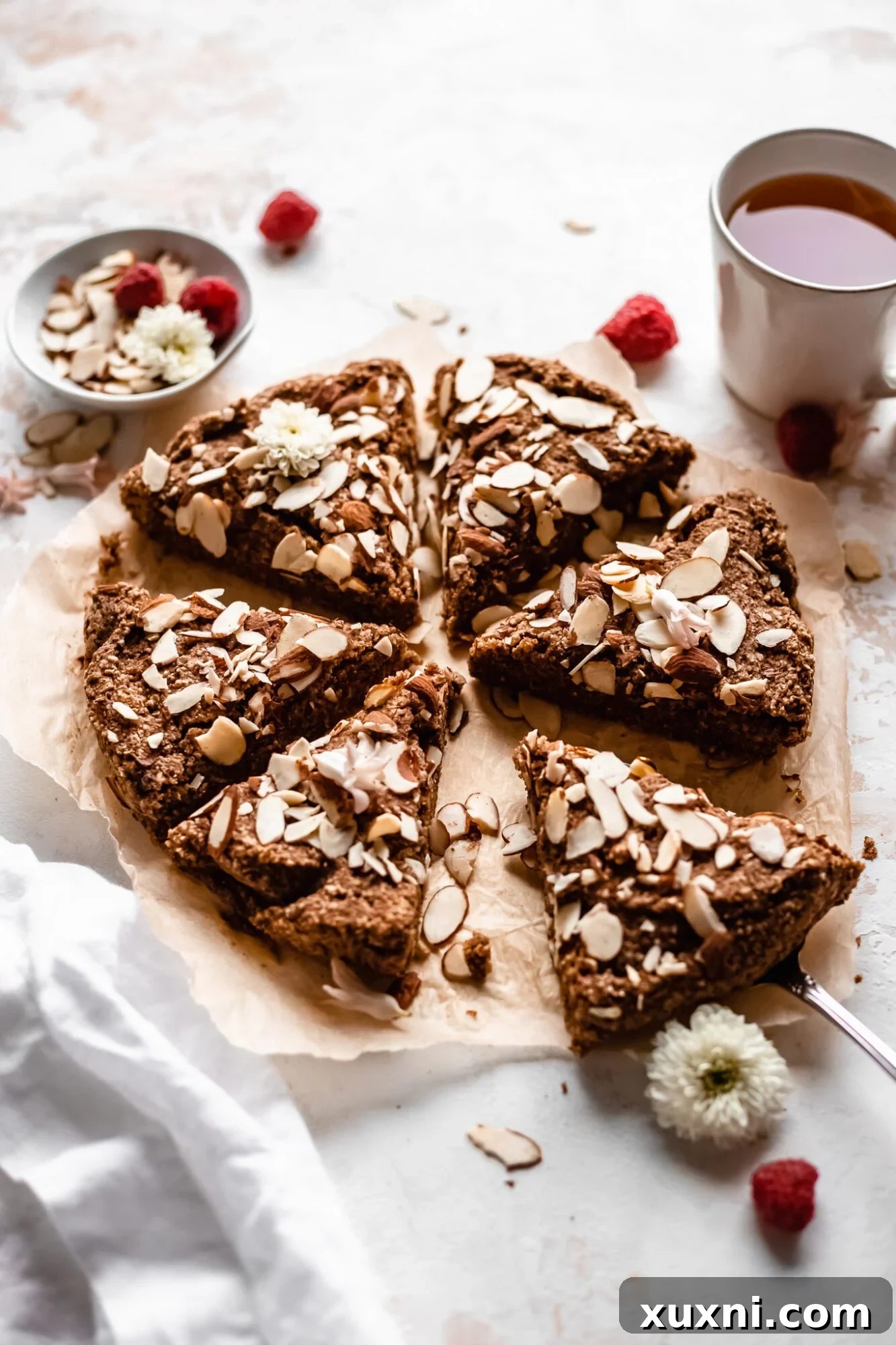 A single slice of moist vegan almond cake on a delicate plate