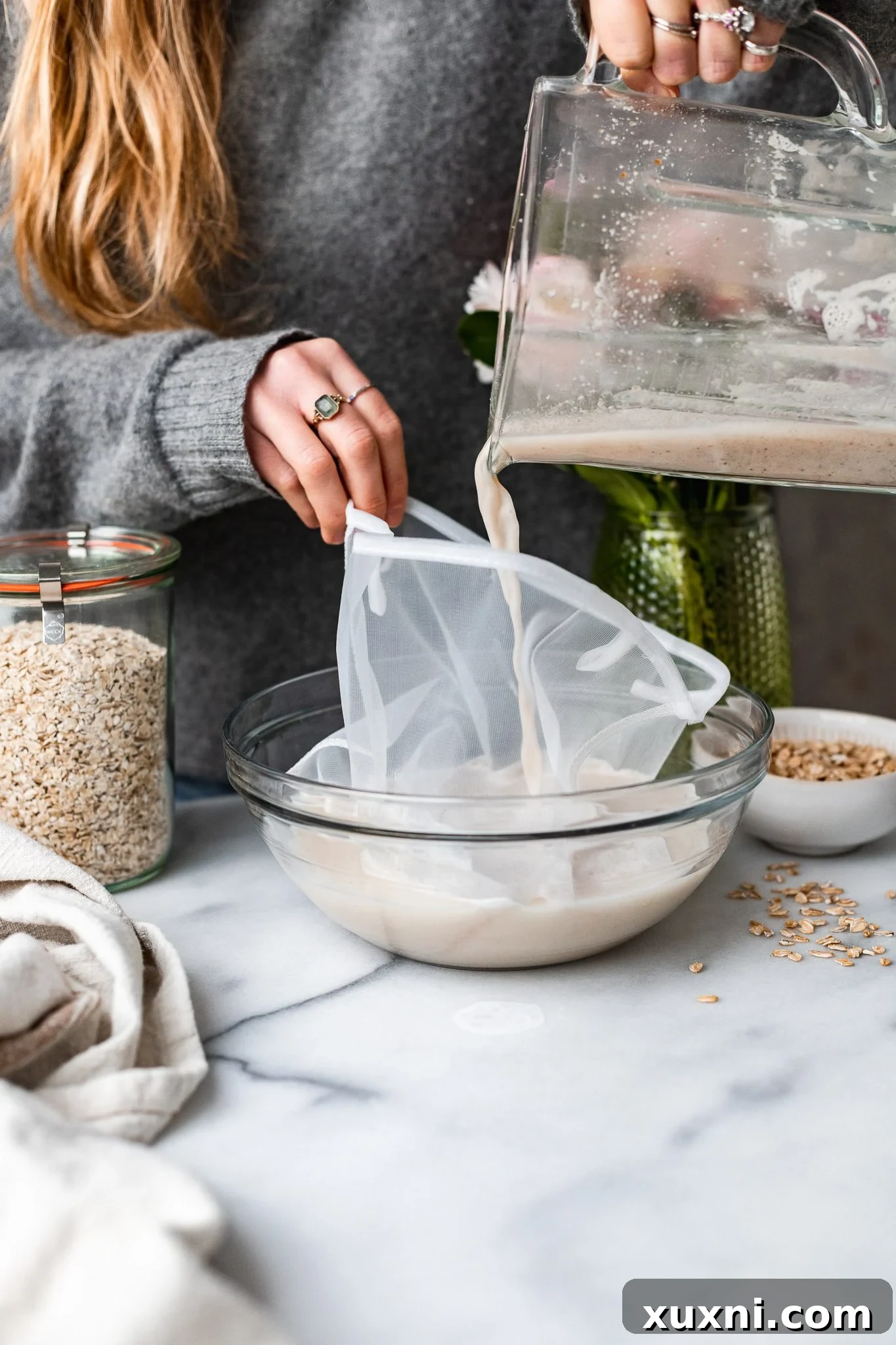 pouring in oat milk for straining