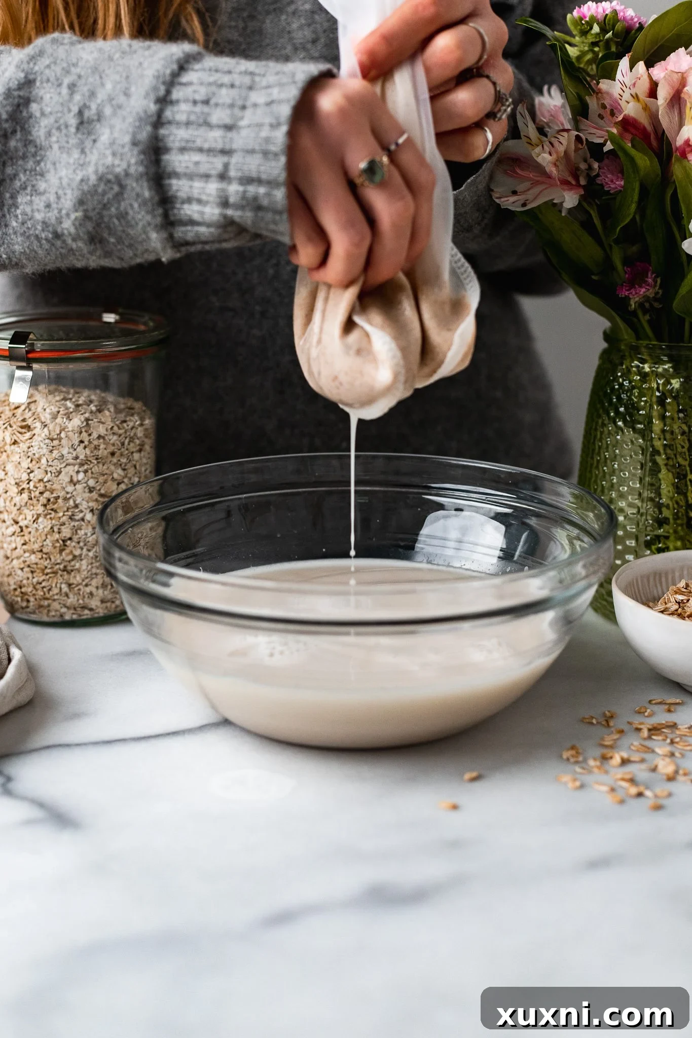 straining oat milk to remove pulp