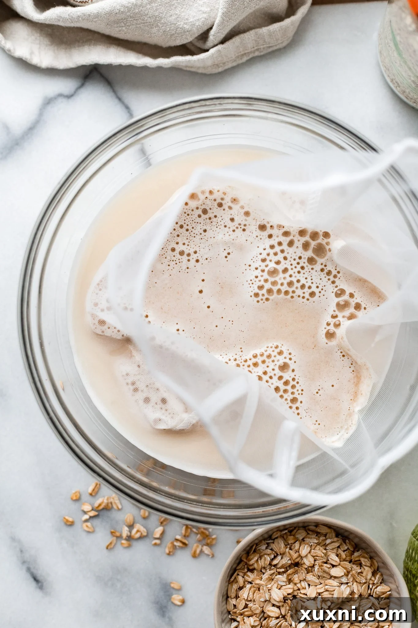 straining oat milk for a second time