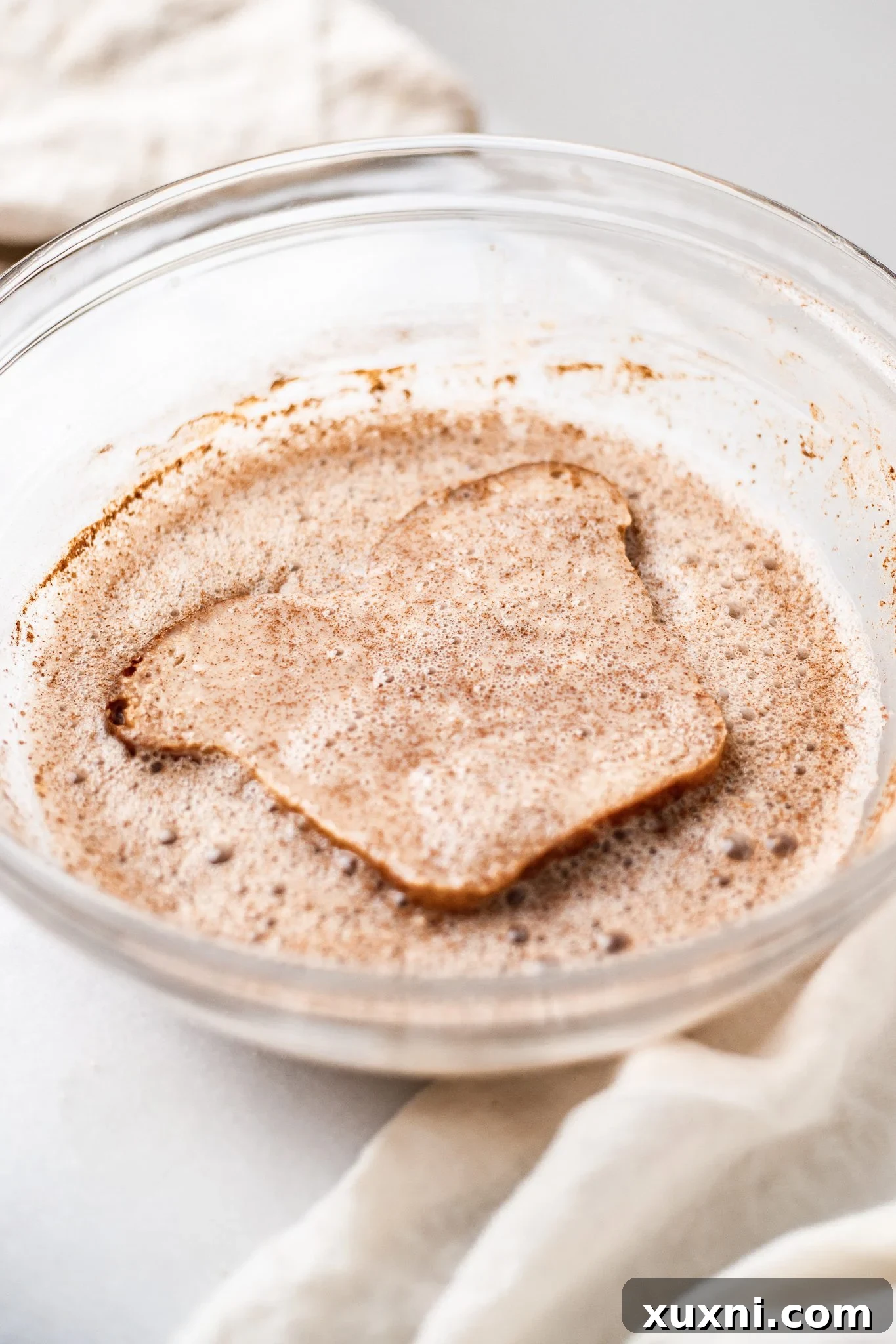 soaking a slice of bread into the French toast batter.