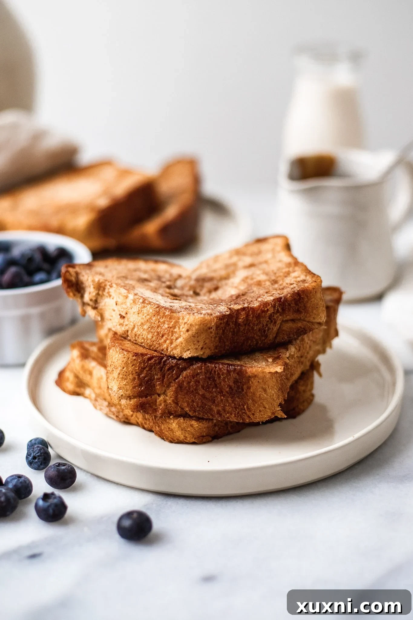 stack of cooked French toast on a white plate.