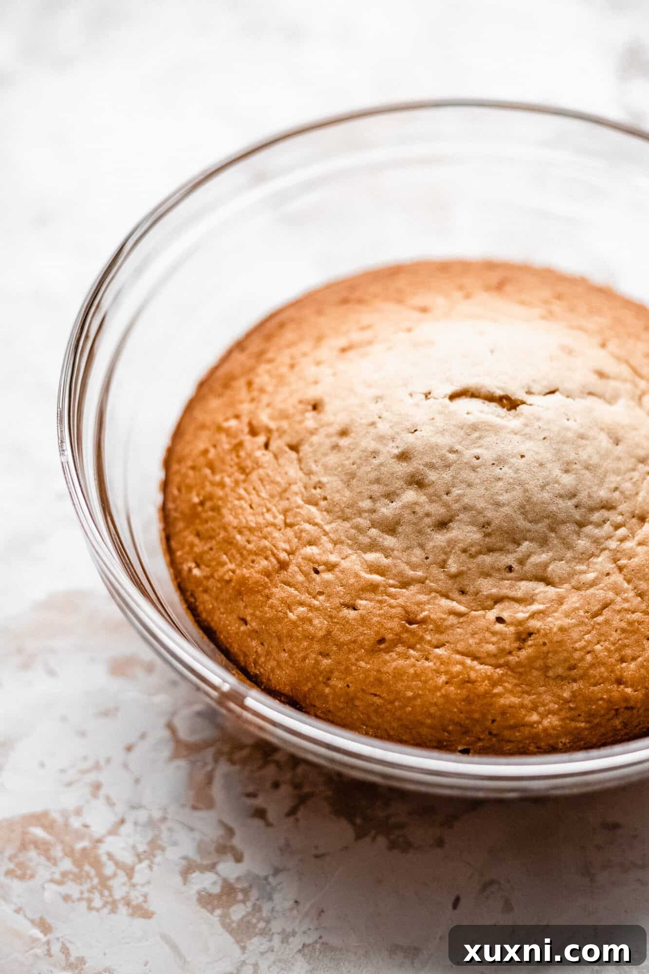 A baked cake still in its glass bowl, showcasing the perfectly rounded shape for the bunny's body
