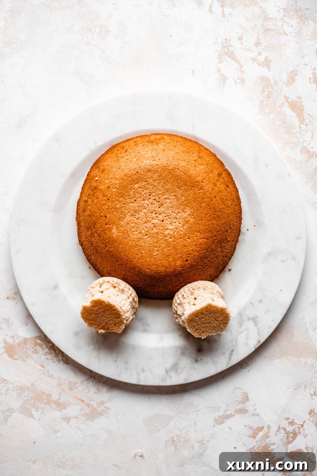 Bunny butt cake with two cupcakes forming the upper legs, awaiting frosting and feet details