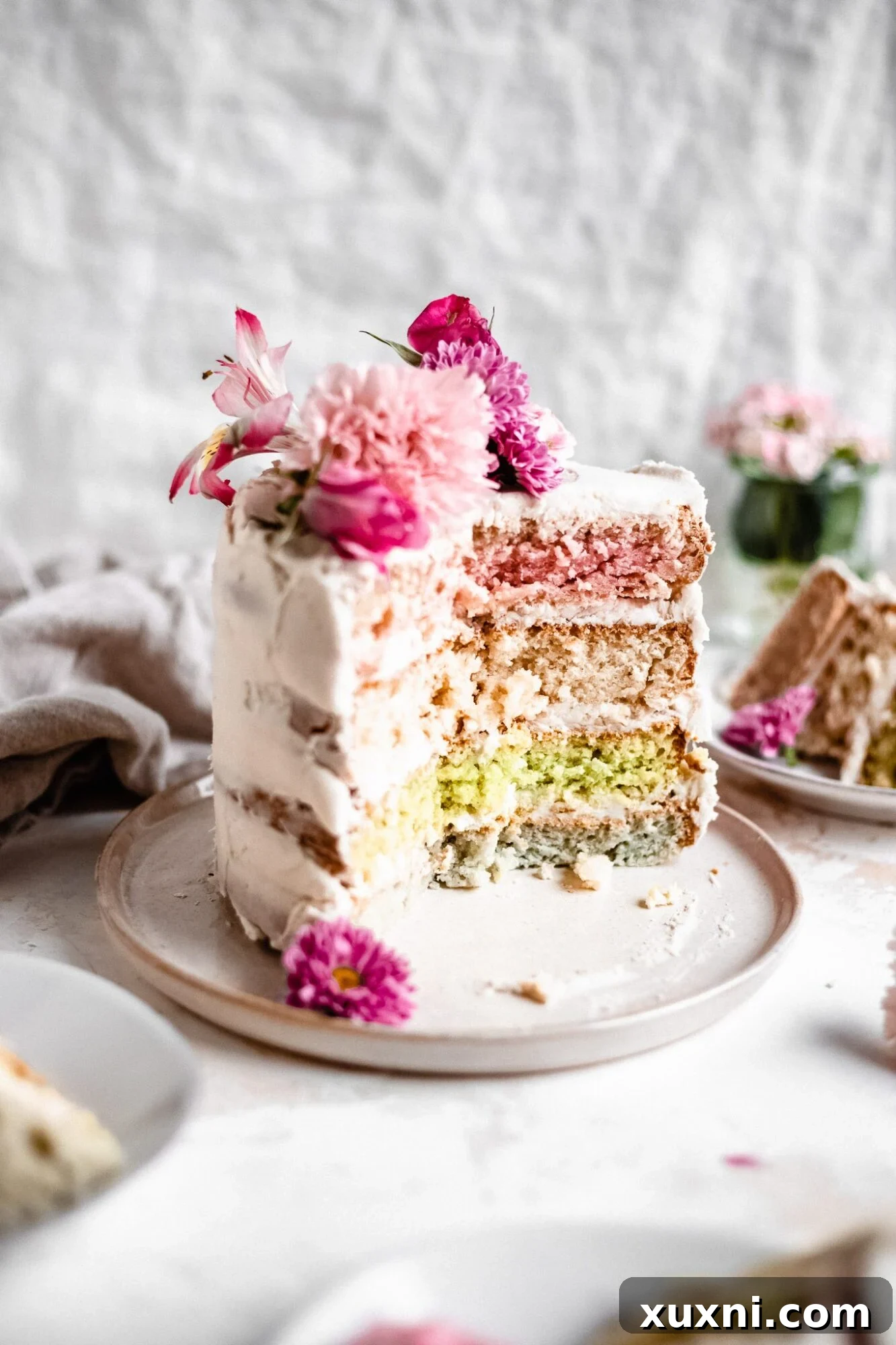 An up-close shot of the vegan pastel layer cake, showcasing the delicate details of the frosting and flowers.