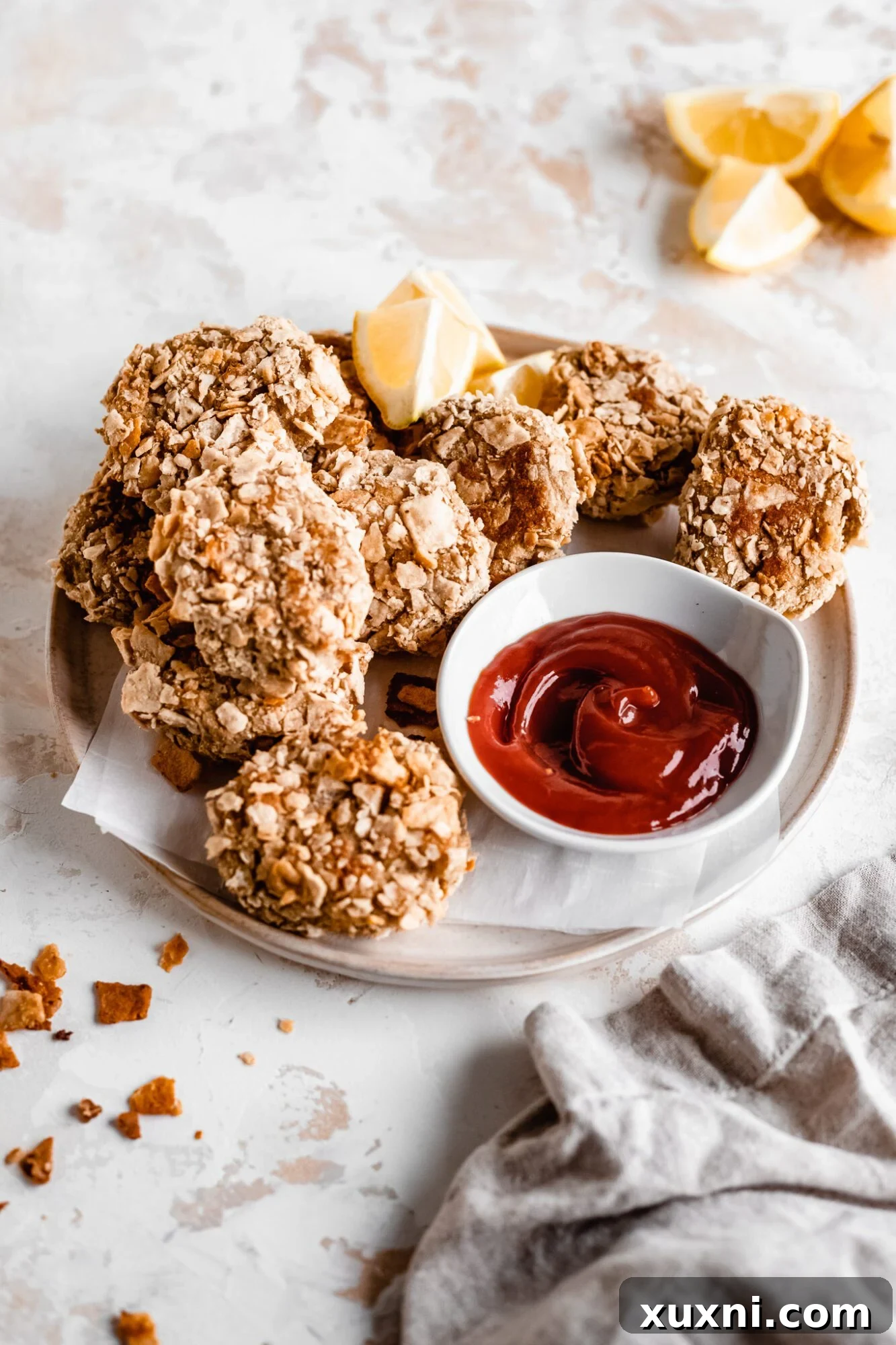 A plate of golden, crispy vegan cauliflower nuggets with dipping sauce, showcasing their appealing texture and readiness to eat.