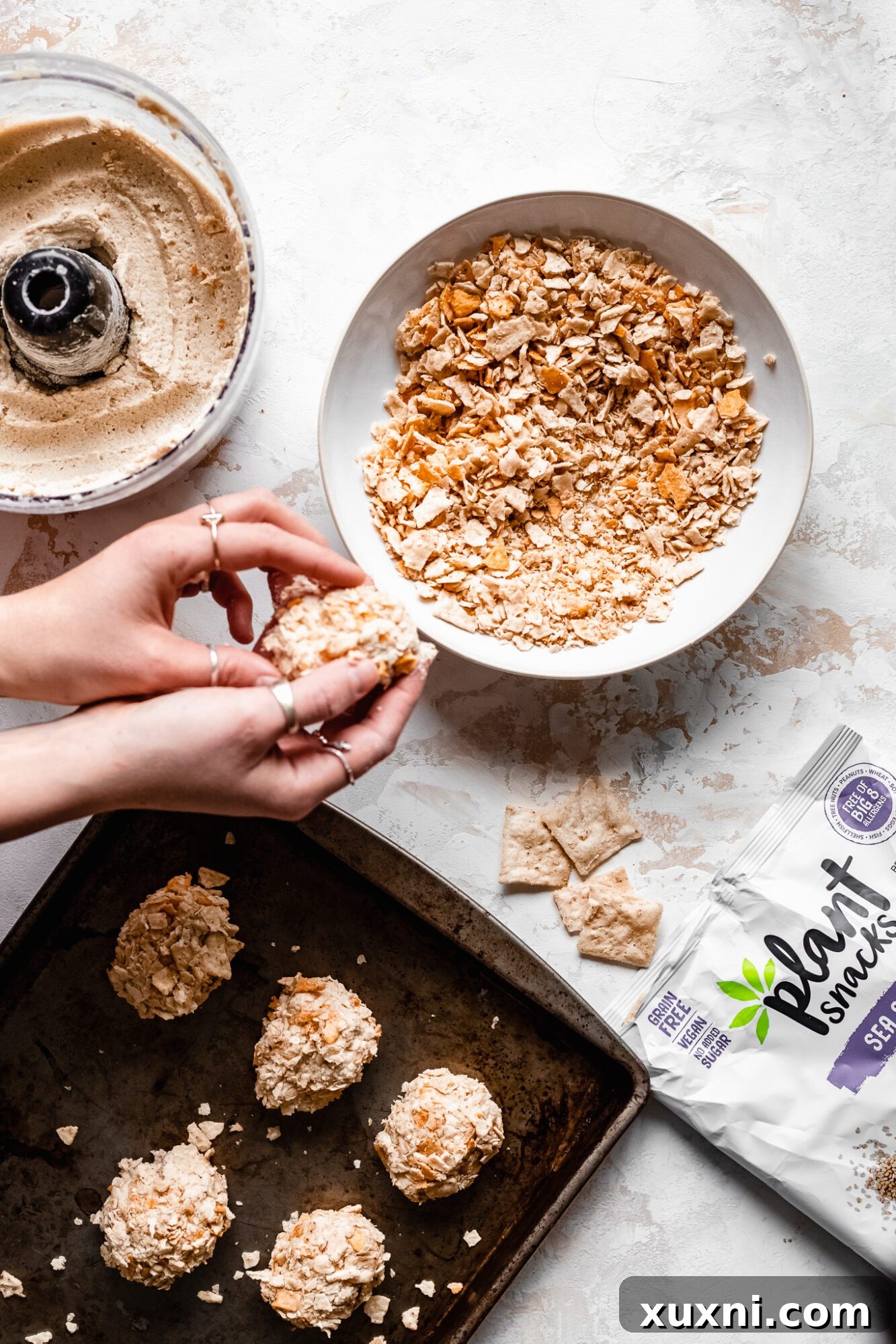 Hands carefully shaping the cauliflower dough into individual vegan chicken nuggets, demonstrating the tactile process.