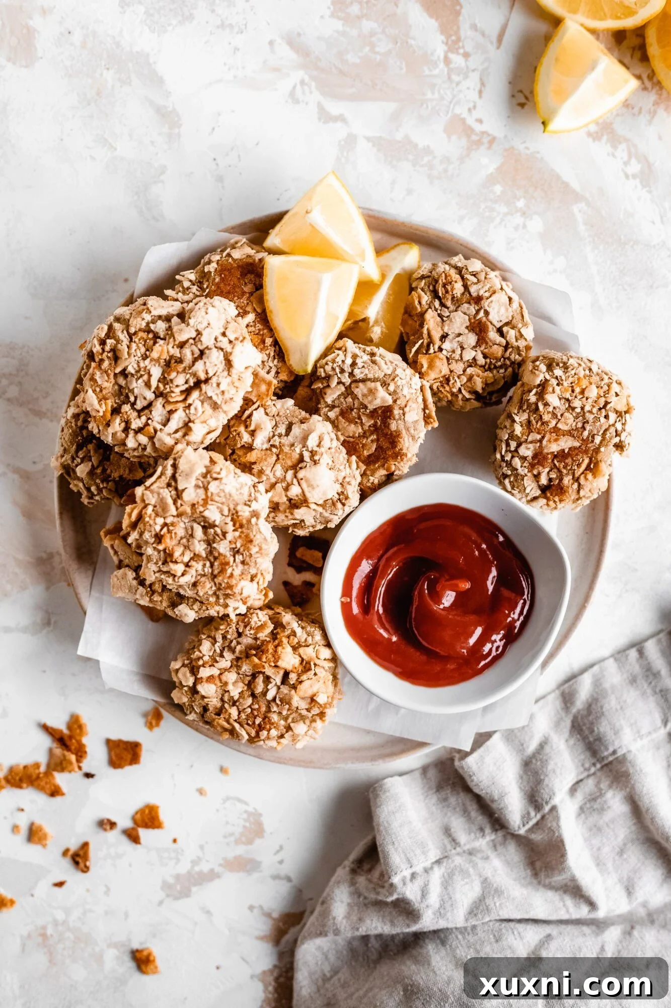A close-up view of several golden-brown vegan cauliflower nuggets arranged on a plate, highlighting their appetizing texture and crispy coating.