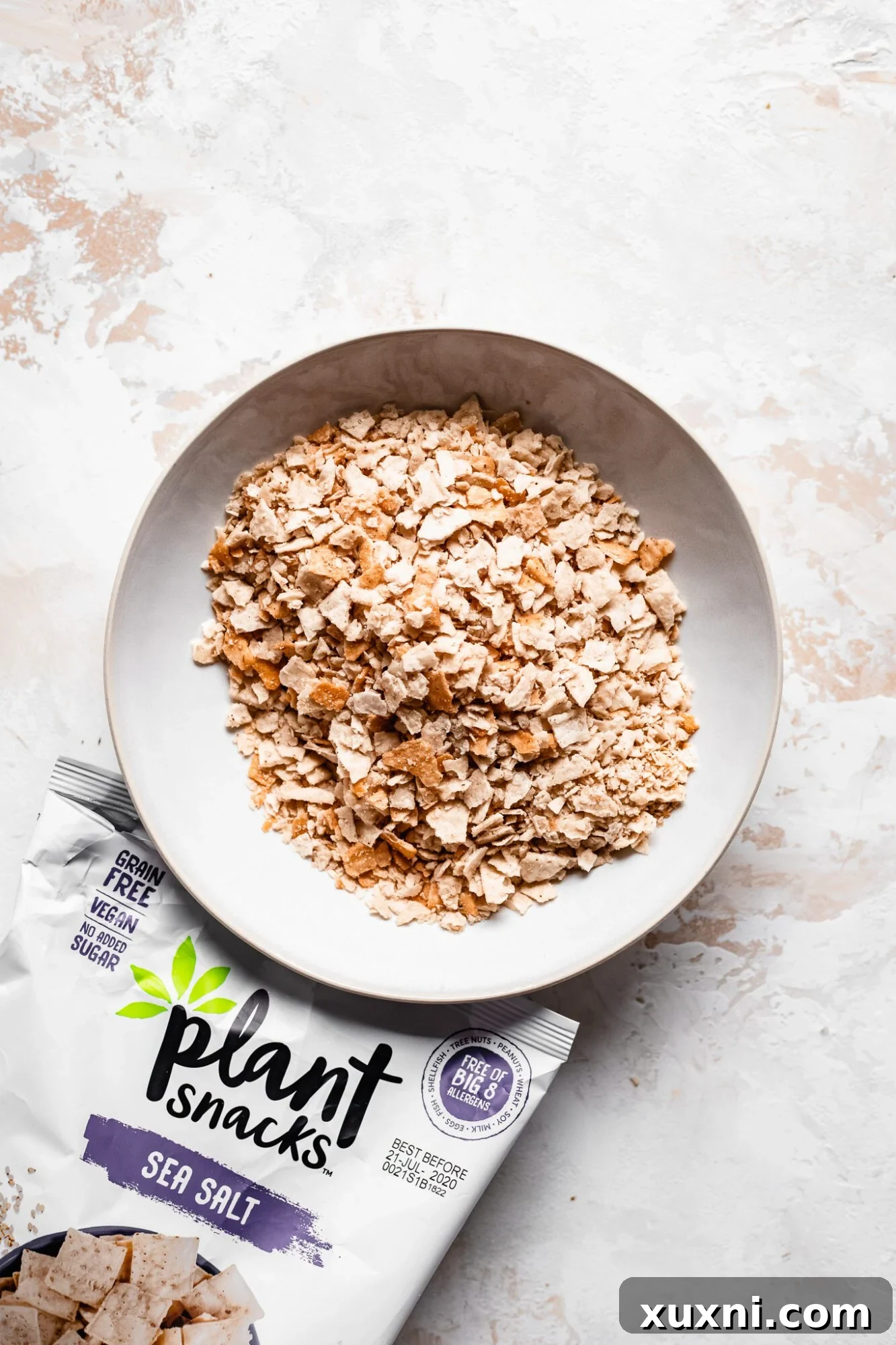 A bowl filled with finely crushed Plant Snacks cassava root chips, ready to be used as a gluten-free and grain-free breading for nuggets.