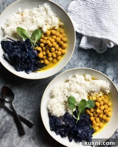 Close-up of a serving of vegan chickpea curry with coconut milk, accompanied by purple cabbage.