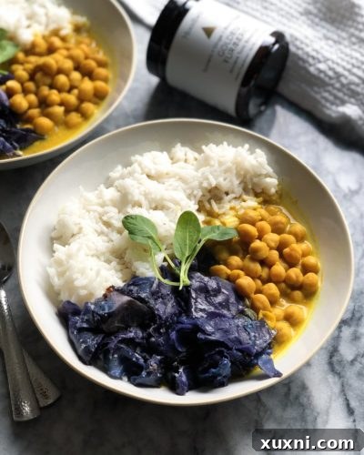 A bowl of hot Vegan Coconut Chickpea Curry ready to be served, garnished with fresh herbs.