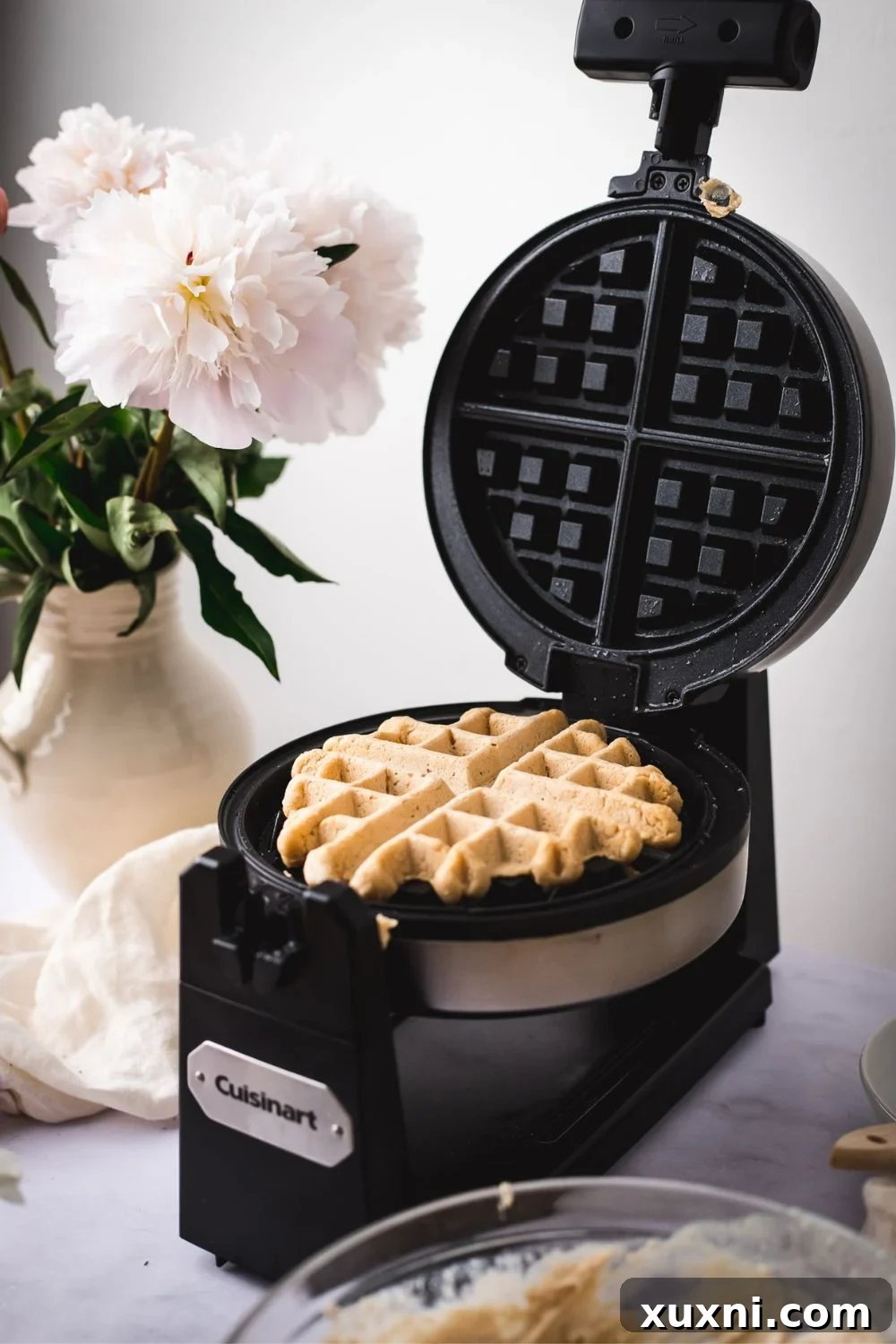 Freshly cooked vegan waffles with a golden-brown crisp, hot off the waffle iron.