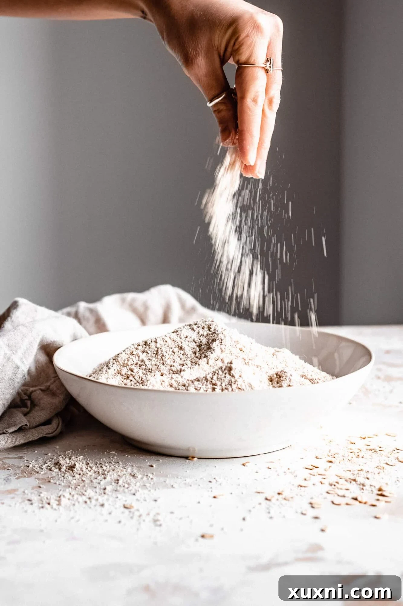 Hand pinching fresh, finely ground oat flour