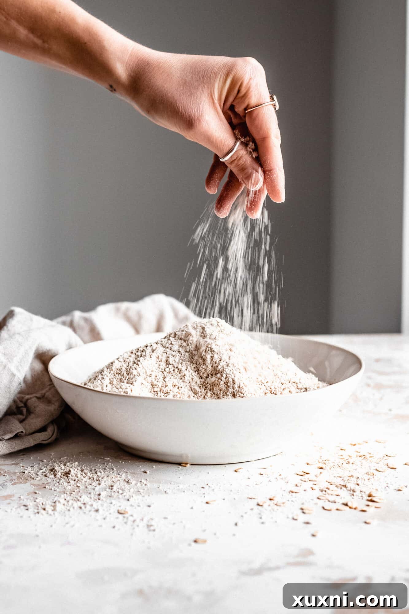 Another close-up of hand pinching oat flour