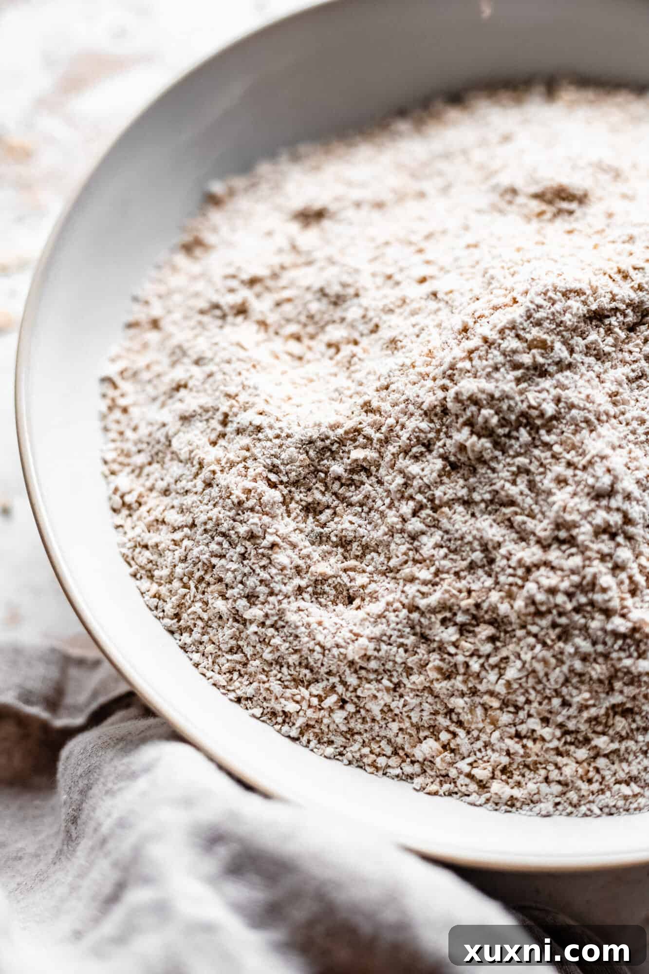 Close-up view of a bowl filled with freshly ground oat flour