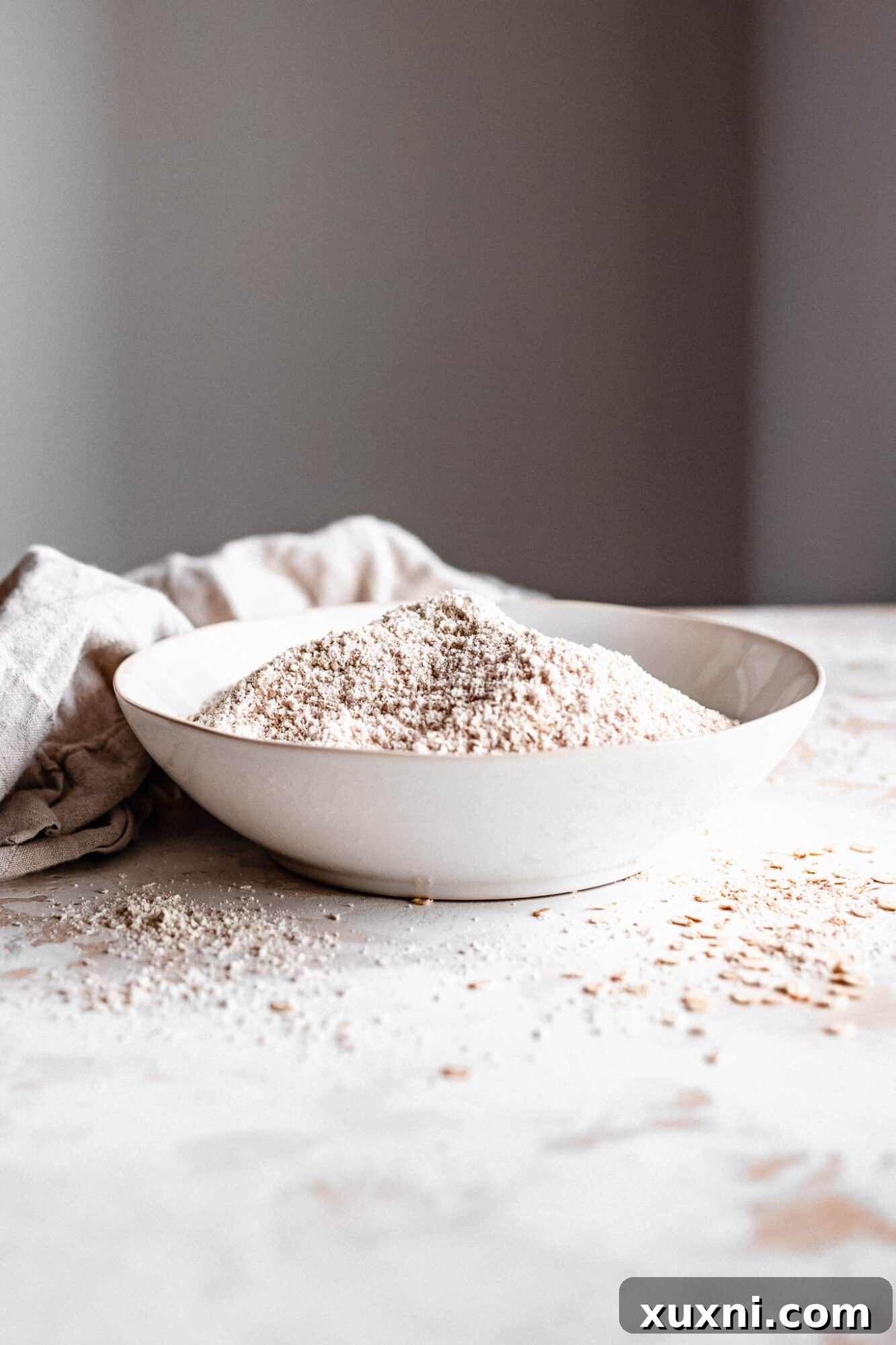 Bowl of freshly made oat flour with a measuring spoon