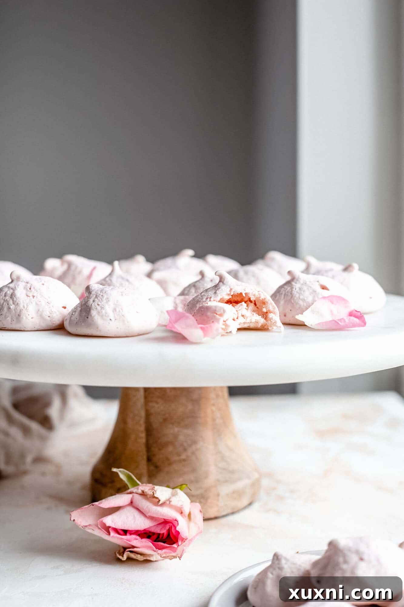 Another view of a delicious, partially bitten vegan meringue cookie, emphasizing its delightful texture.
