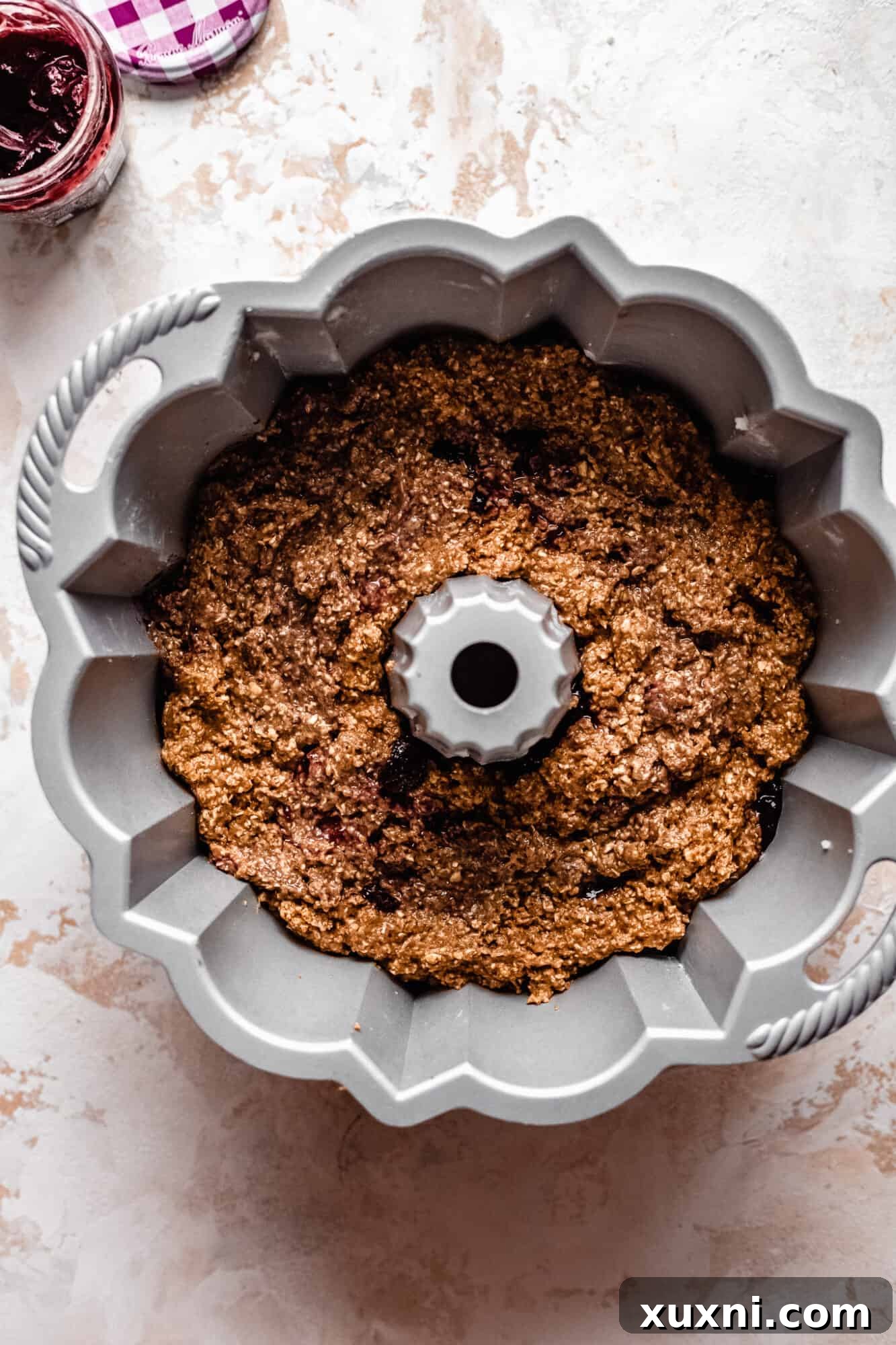 Swirled bundt cake batter, showing the delicate fruit spread pattern.