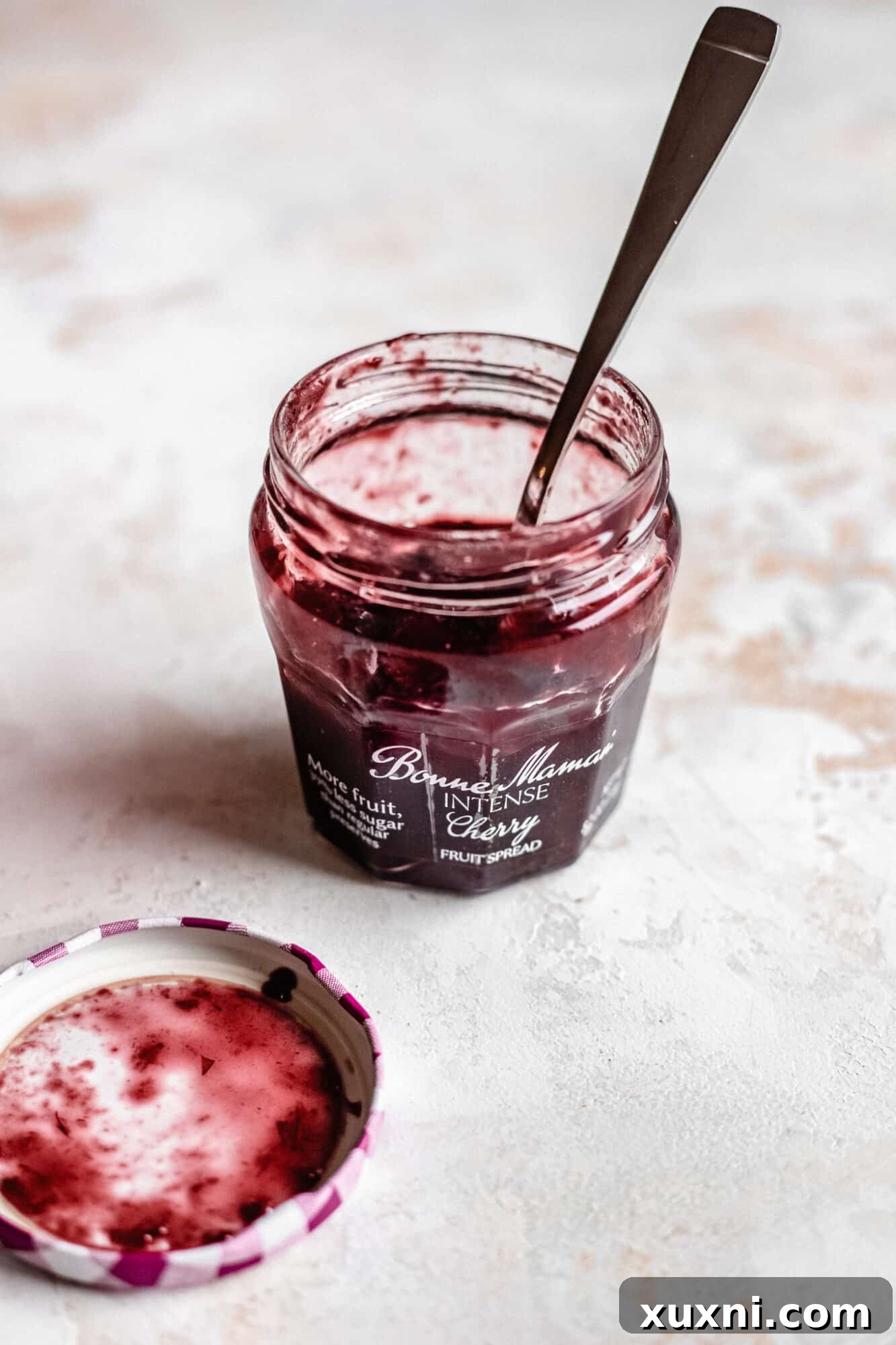 A jar of Bonne Maman INTENSE Cherry Fruit Spread, showcasing its rich texture.