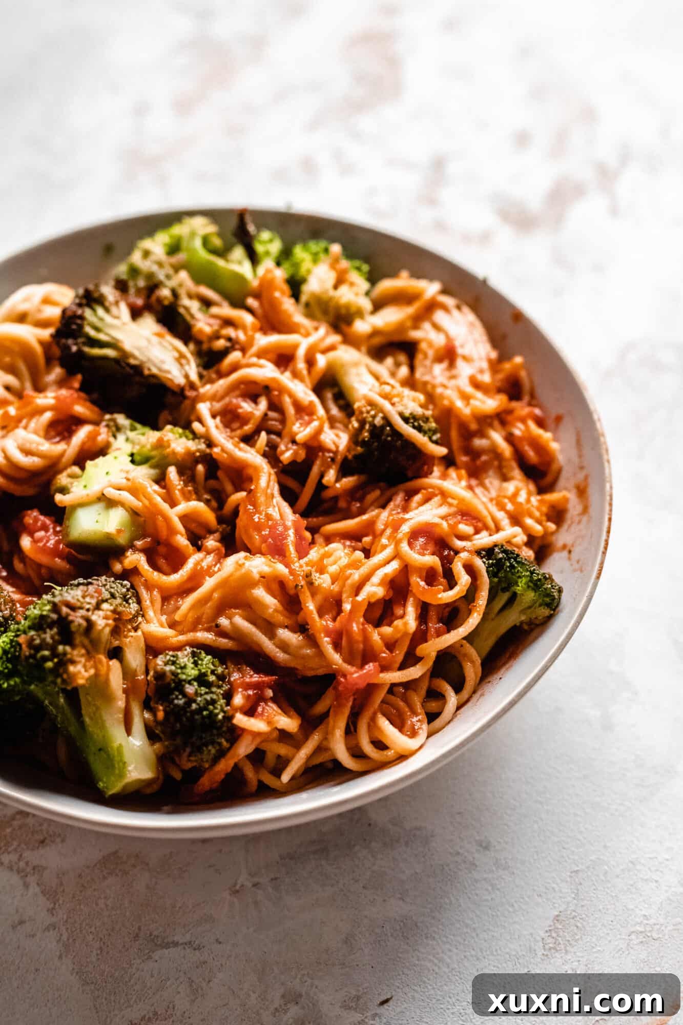 A plate of spaghetti and broccoli, a simple and hearty vegan pantry meal, enhanced with chickpea pasta.