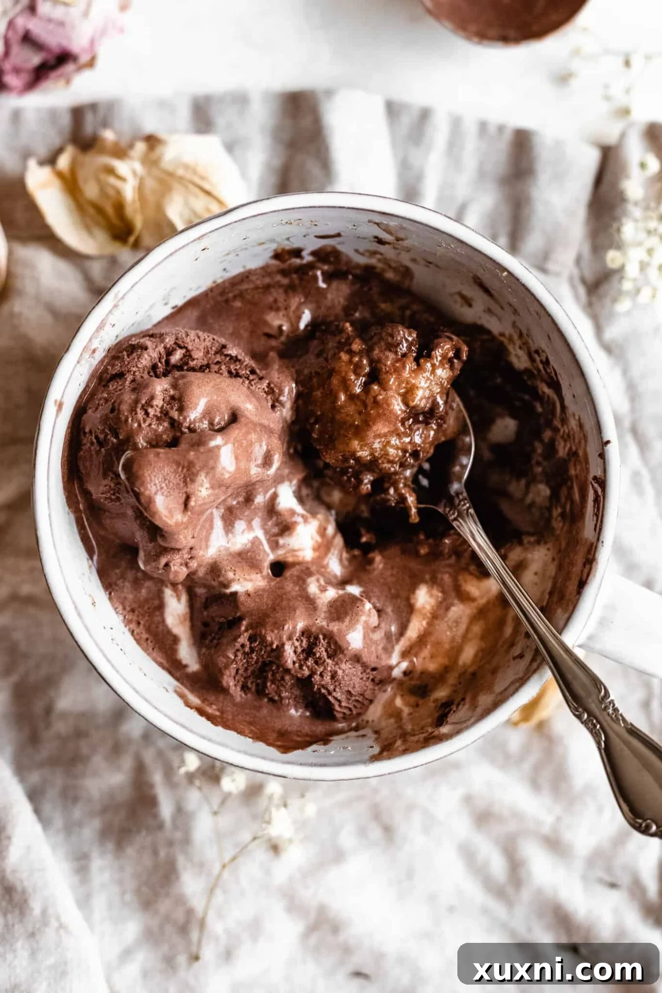 Close-up of a spoonful of vegan cookie mug cake, showcasing its rich chocolate and tender texture