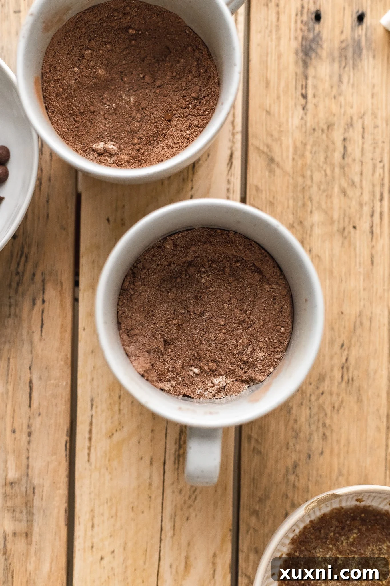 Magical Vegan Chocolate Mug Cake Gluten Free Oil Free Bliss 5 Close-up of a fork whisking dry ingredients like flour, cocoa, and sugar in a white mug.