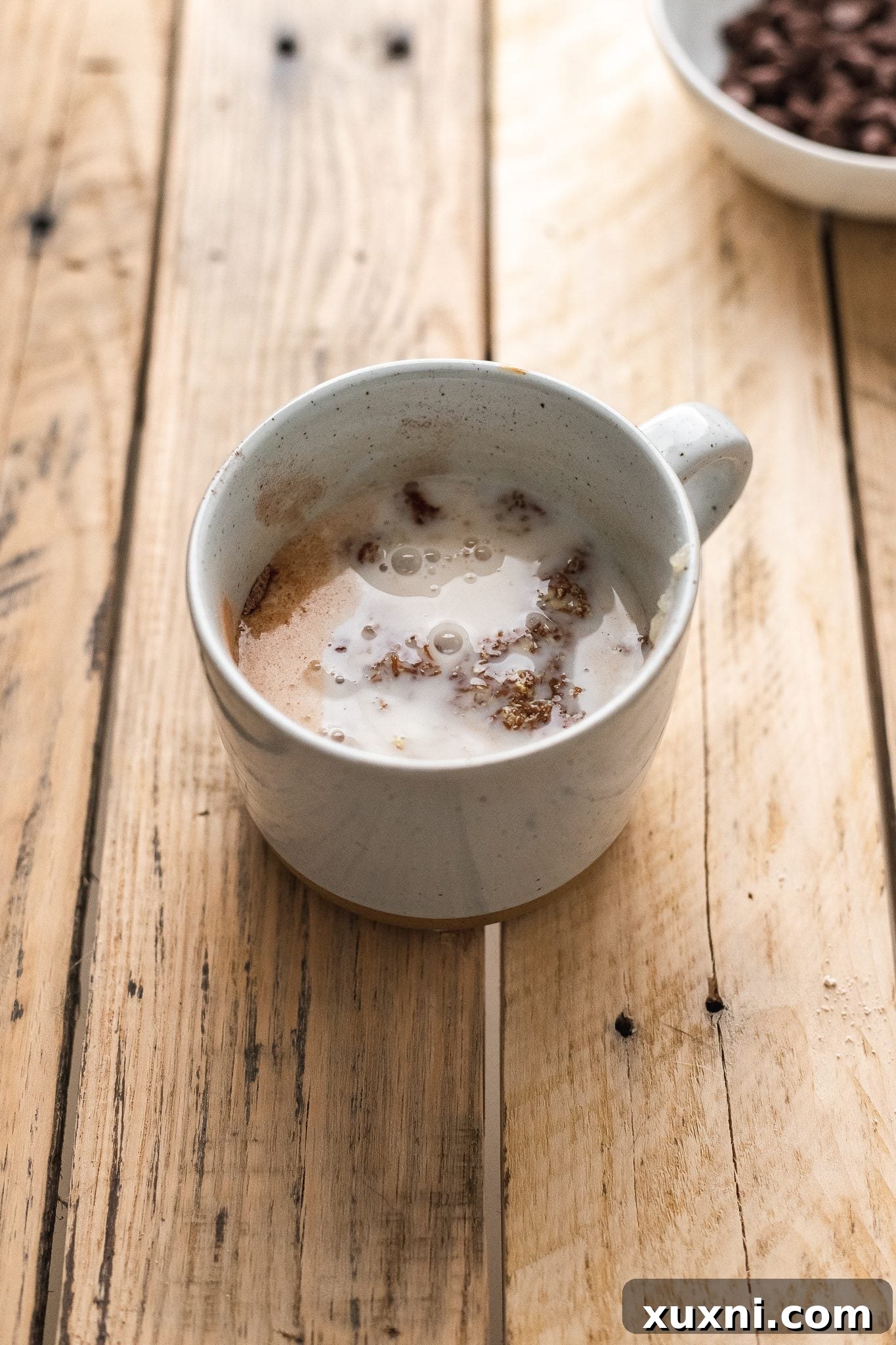 Magical Vegan Chocolate Mug Cake Gluten Free Oil Free Bliss 6 All the wet ingredients, including flax egg, milk, and applesauce, being added to the dry mixture in a mug.