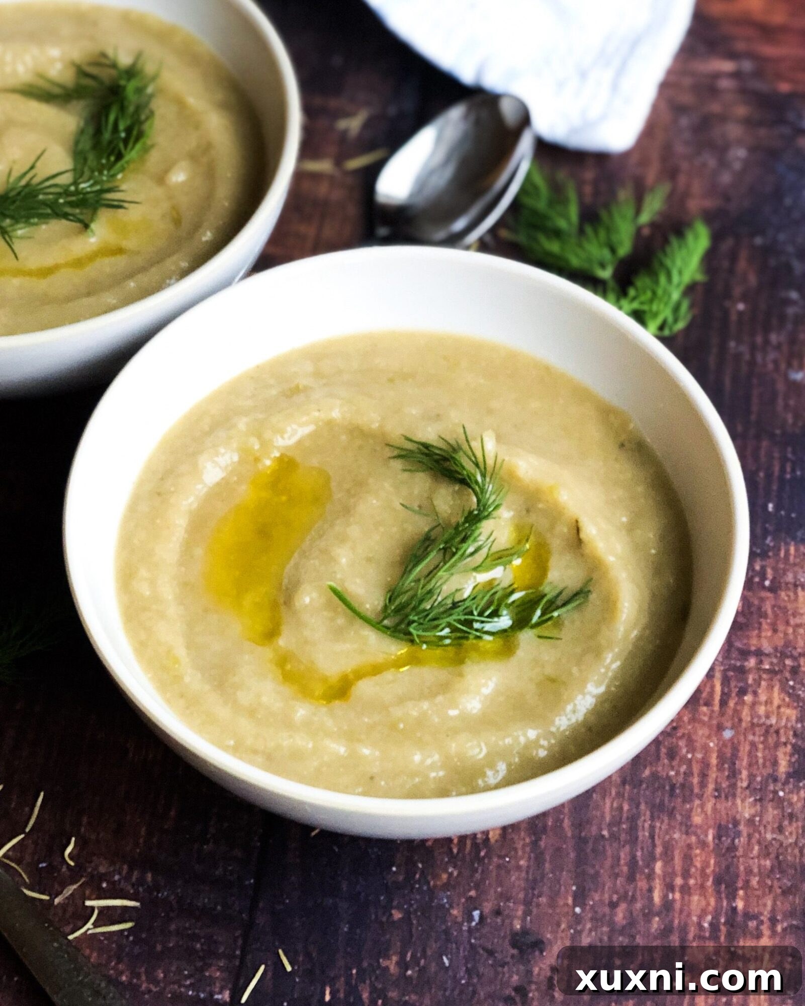 Creamy Vegan Cauliflower Delight 4 A close-up shot of creamy cauliflower soup, presented in a rustic bowl, garnished with a drizzle of olive oil, symbolizing a simple yet elegant healthy meal.