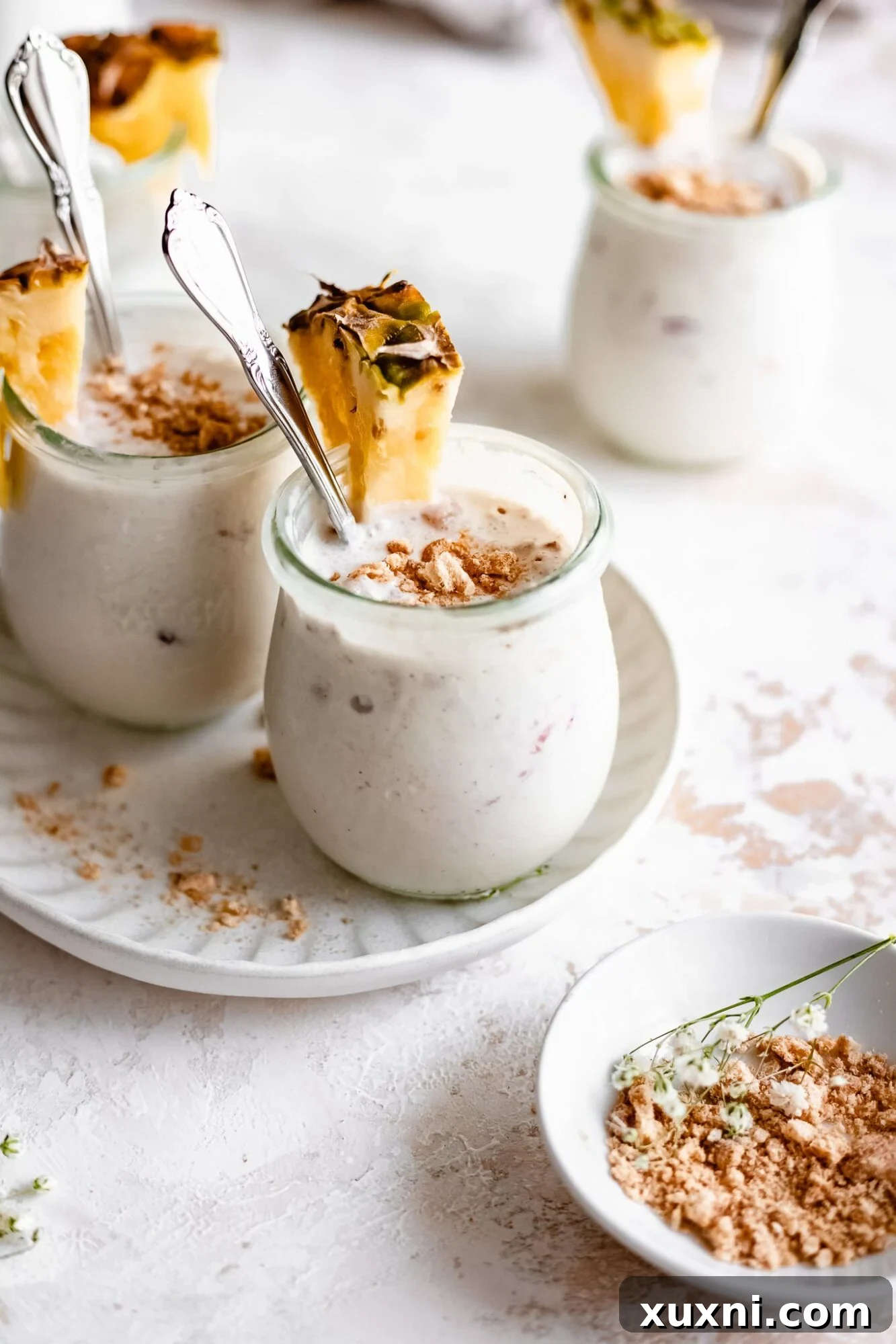 A jar of smooth, creamy vegan vanilla pudding, garnished with fresh pineapple slices and a hint of tropical bliss.