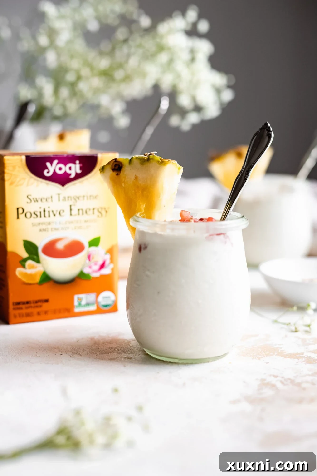 A close-up of a jar of vegan vanilla pudding, perfectly paired with a box of Yogi Tea, emphasizing the unique tea infusion.