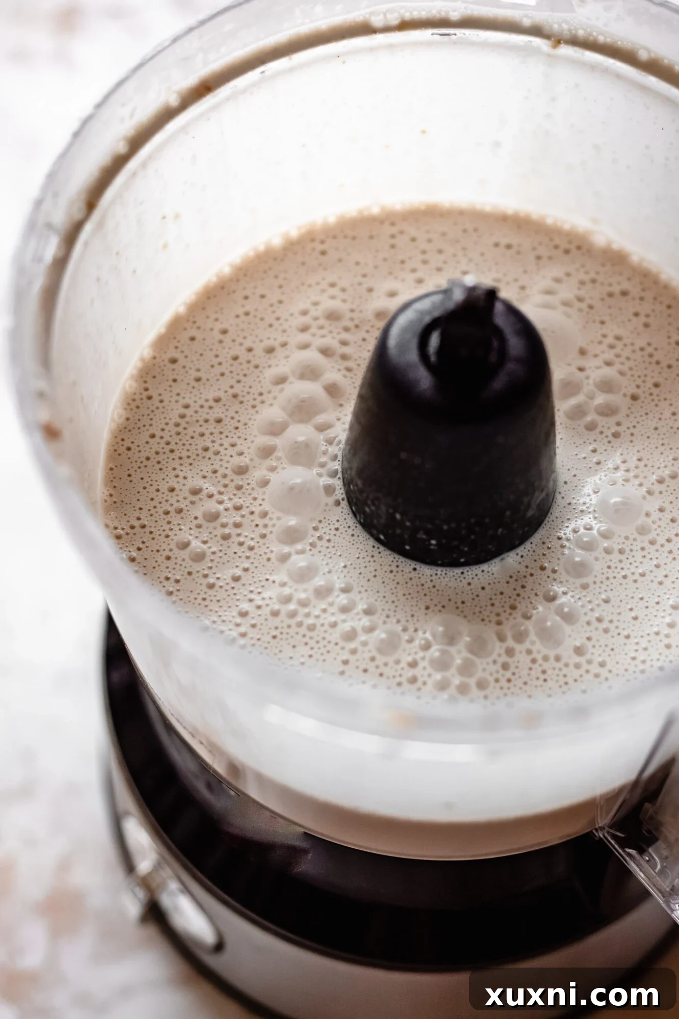 Vegan vanilla pudding ingredients being blended in a food processor, creating a smooth and creamy mixture.