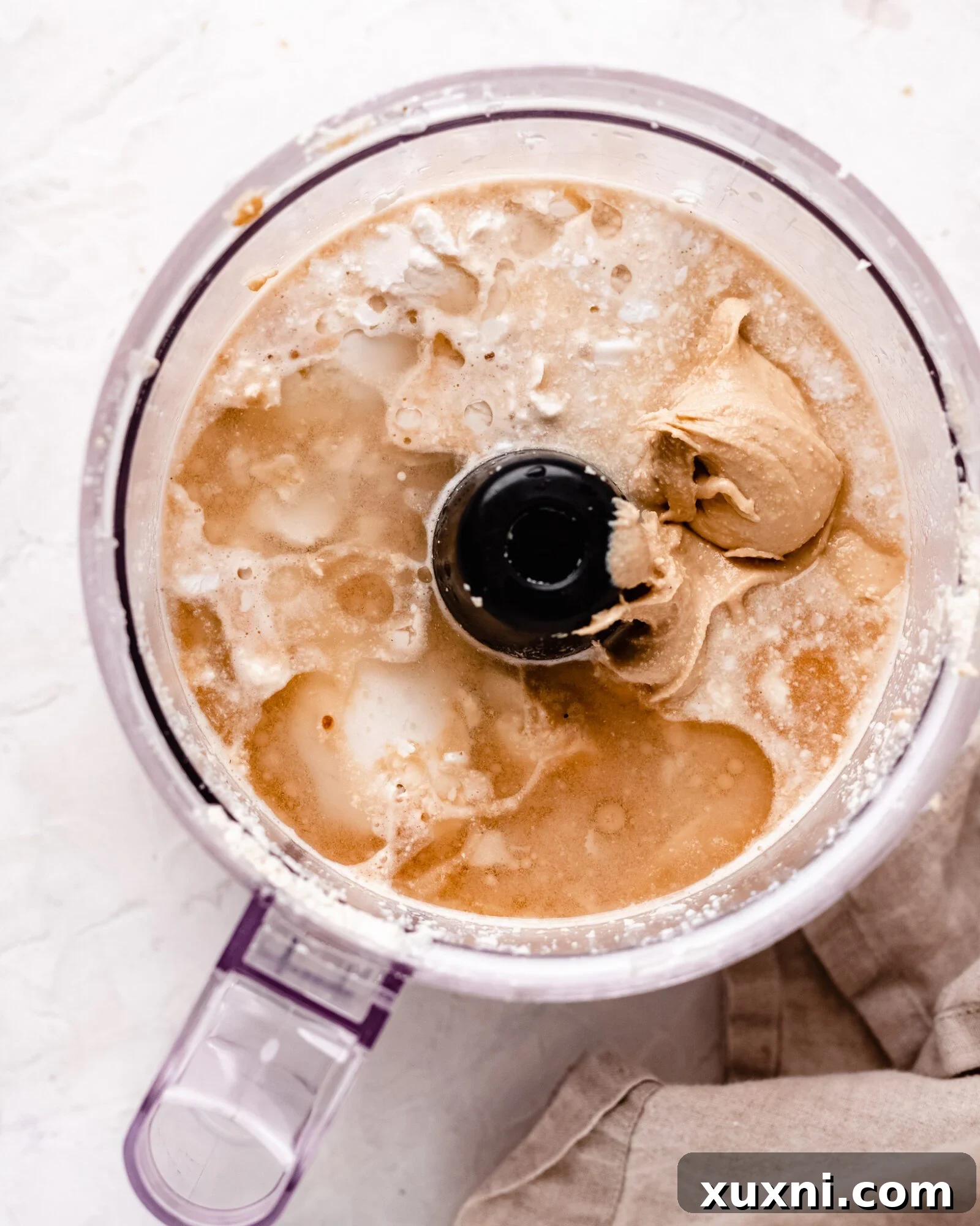 Cashew milk ice cream ingredients being added to a food processor.