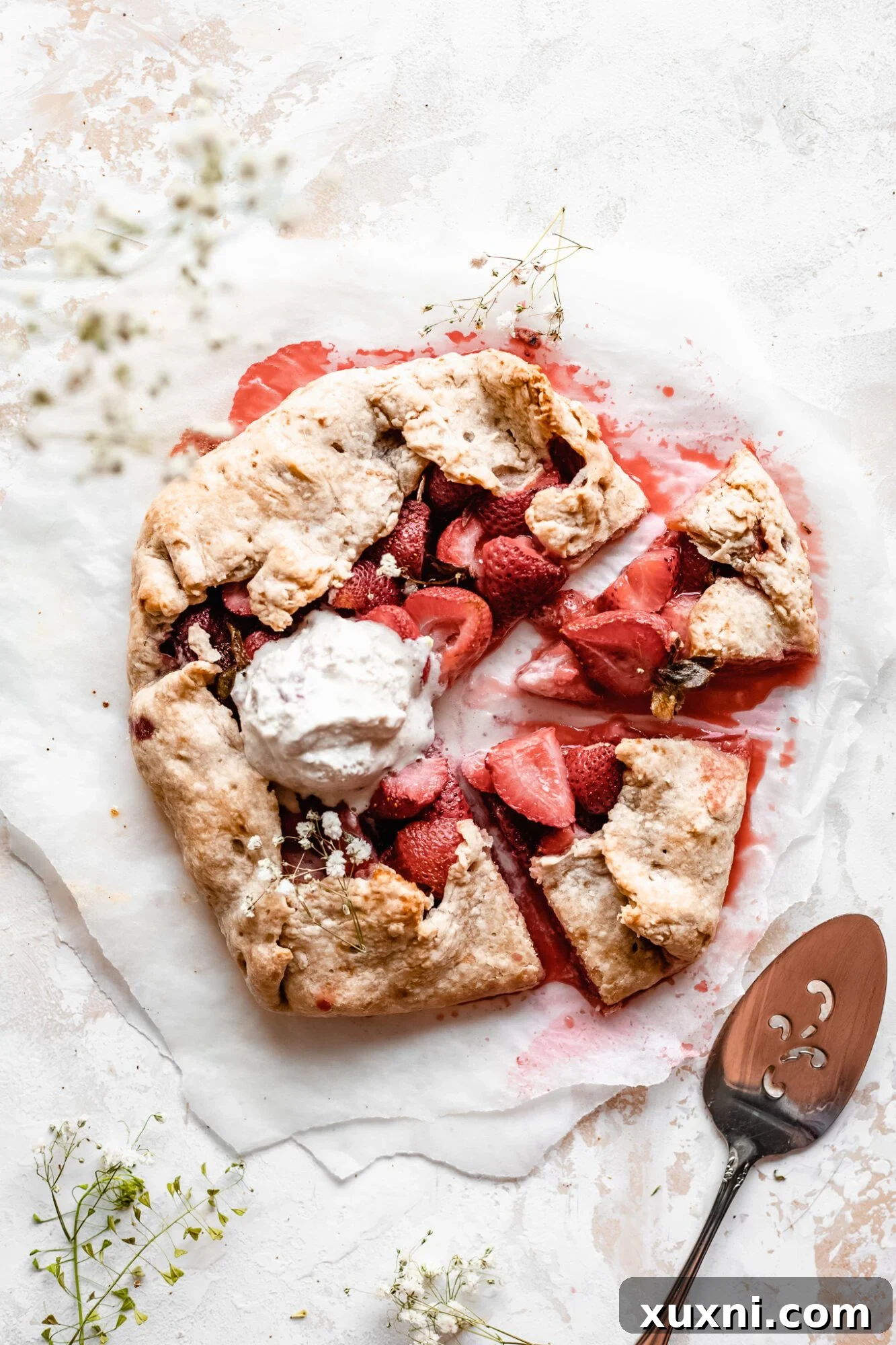 Multiple slices of strawberry galette on a white background, highlighting its golden crust and vibrant fruit