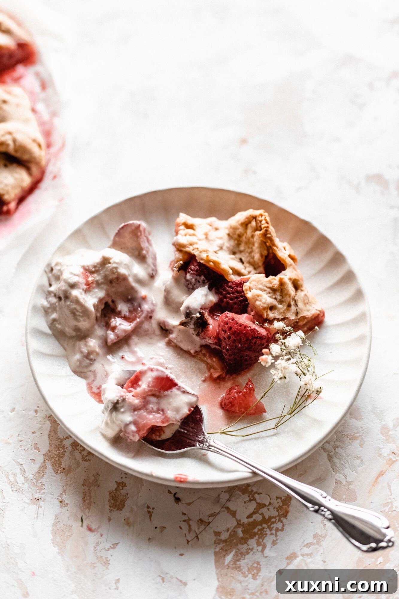 A partially eaten slice of strawberry galette on a plate, showing the texture and deliciousness