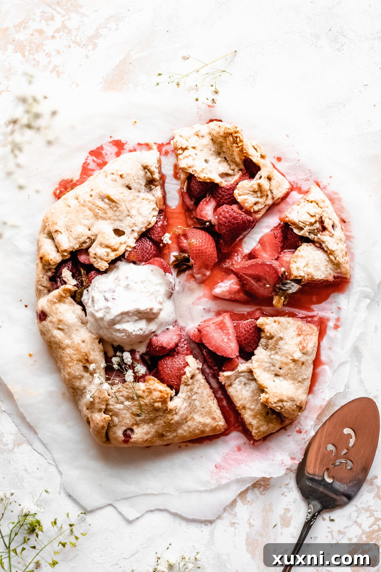Multiple slices of vegan strawberry galette arranged on a serving plate, showcasing the golden-brown crust and berry filling