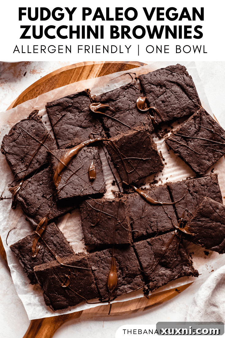 Decadent Paleo Vegan Zucchini Brownies 14 Pinterest image for zucchini brownies, showing a hand holding a brownie