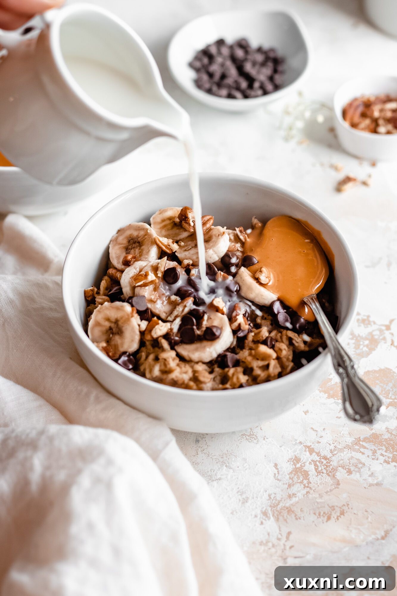 Instant Pot Protein Packed Vegan Zucchini Oatmeal 16 hand pouring oat milk over a bowl of prepped zucchini oatmeal for reheating