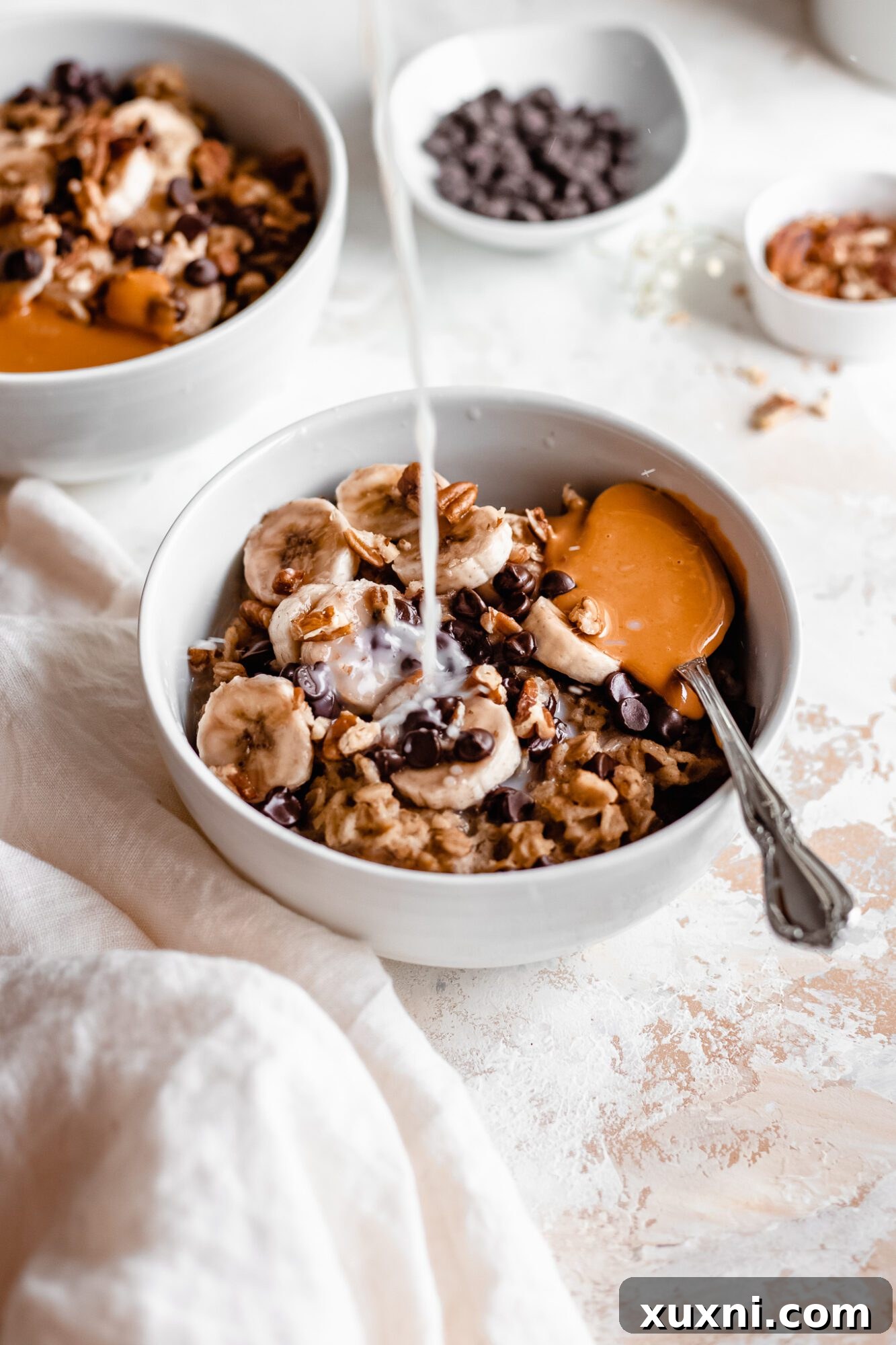 Instant Pot Protein Packed Vegan Zucchini Oatmeal 6 hand pouring plant-based milk over zucchini oatmeal in a bowl